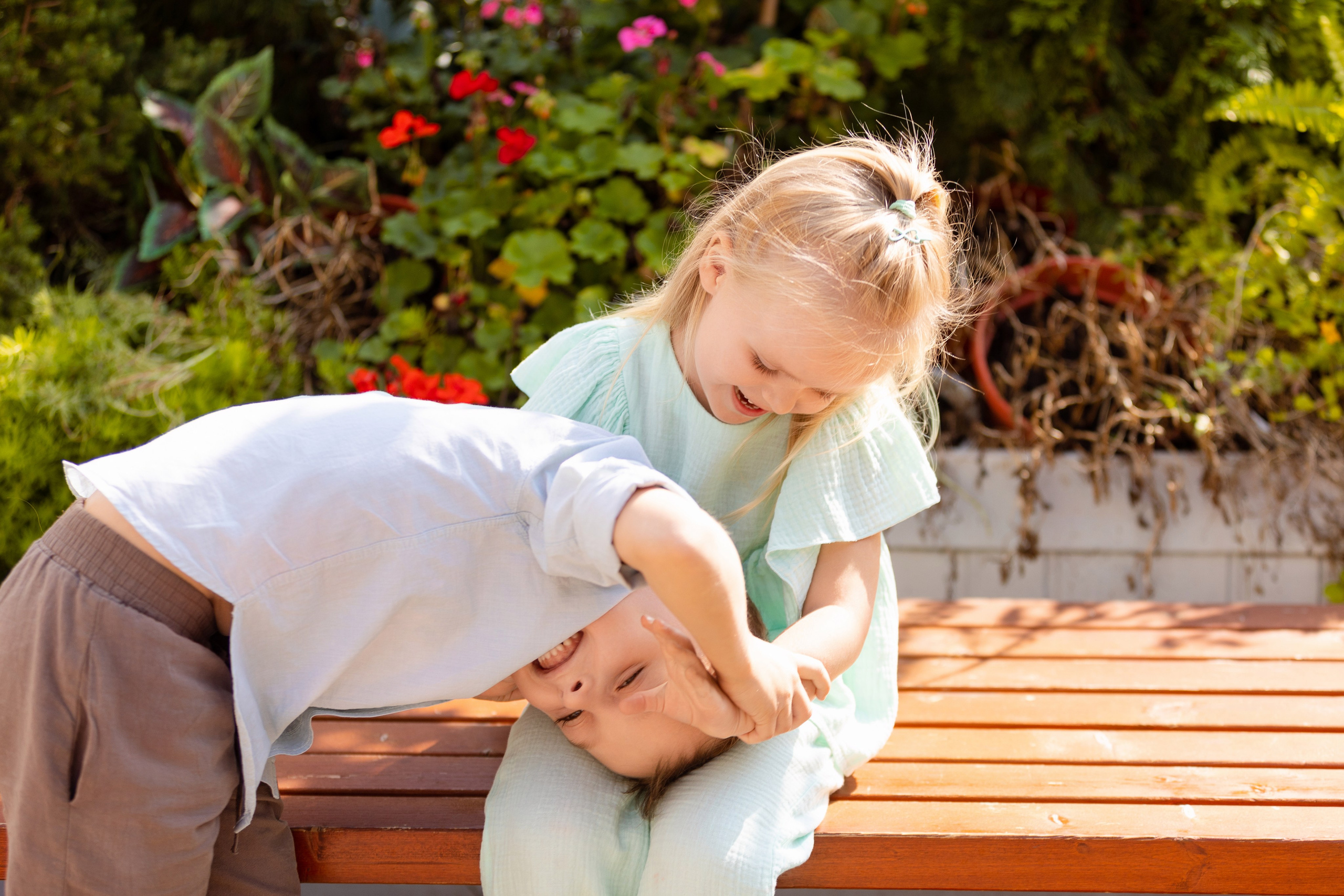 Брат и сестра в парке весело играютдруг с другом