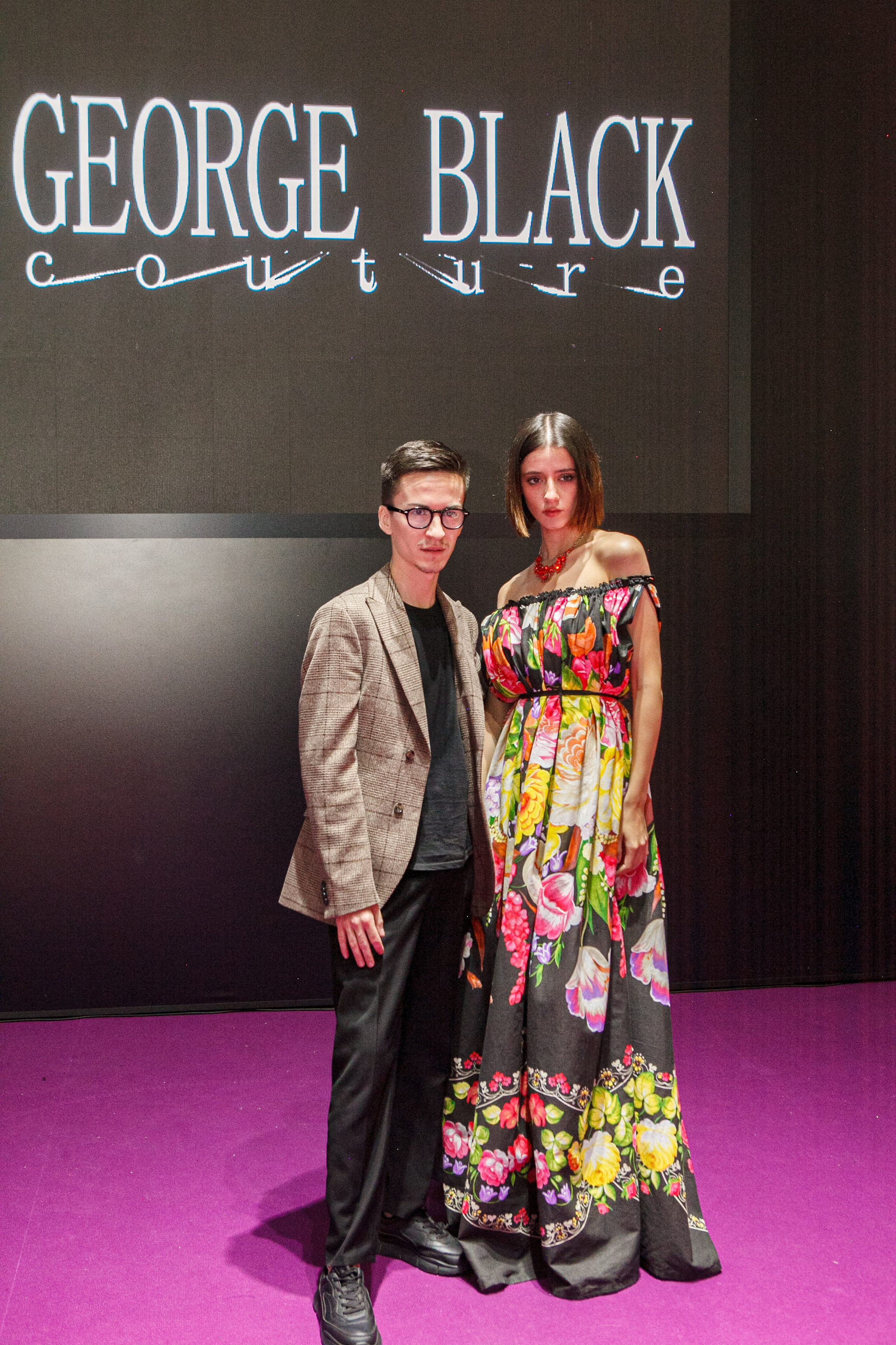  "Модели в ярких нарядах проходят по подиуму во время показа мод, освещенные яркими софитами и окруженные восторженными зрителями."