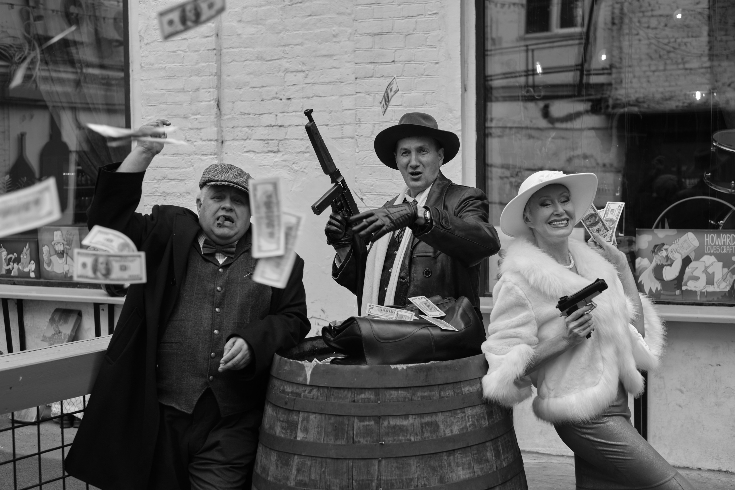 Двое мужчин в женщина бросают деньги в камеру