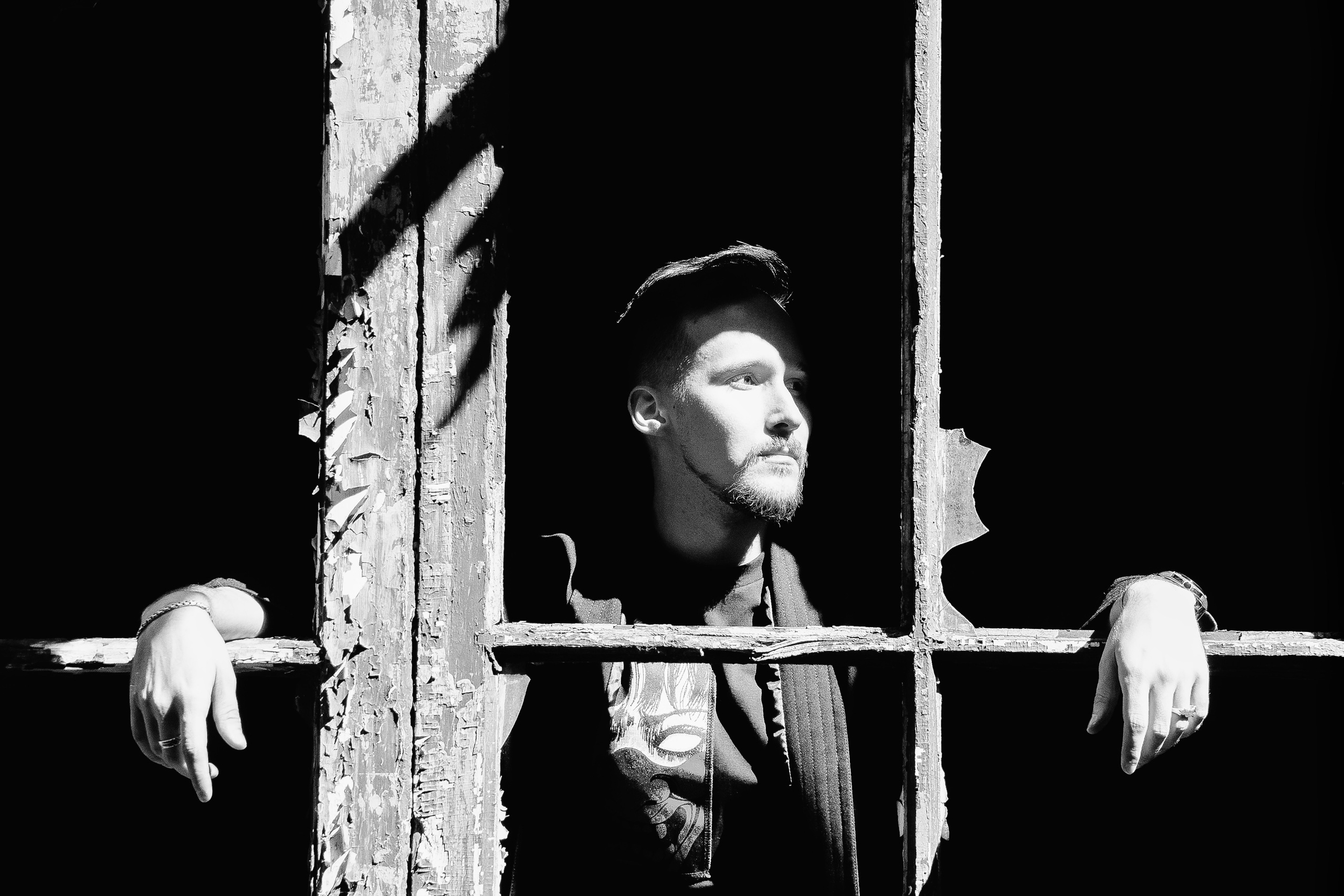 Мужчина смотрит из разбитого окна, Черно-белая сьемка