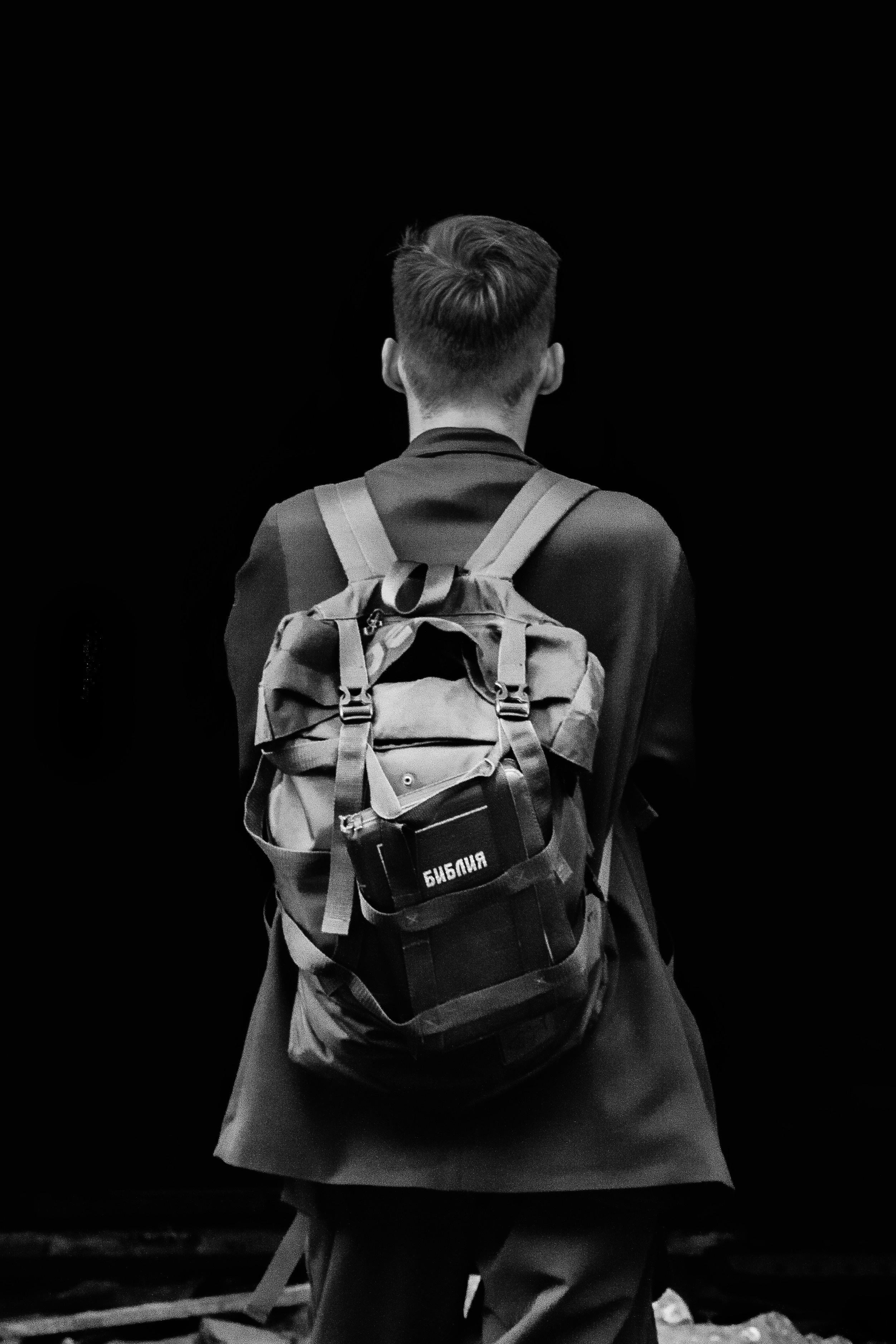 Мужчина с библией на фоне темного пространства