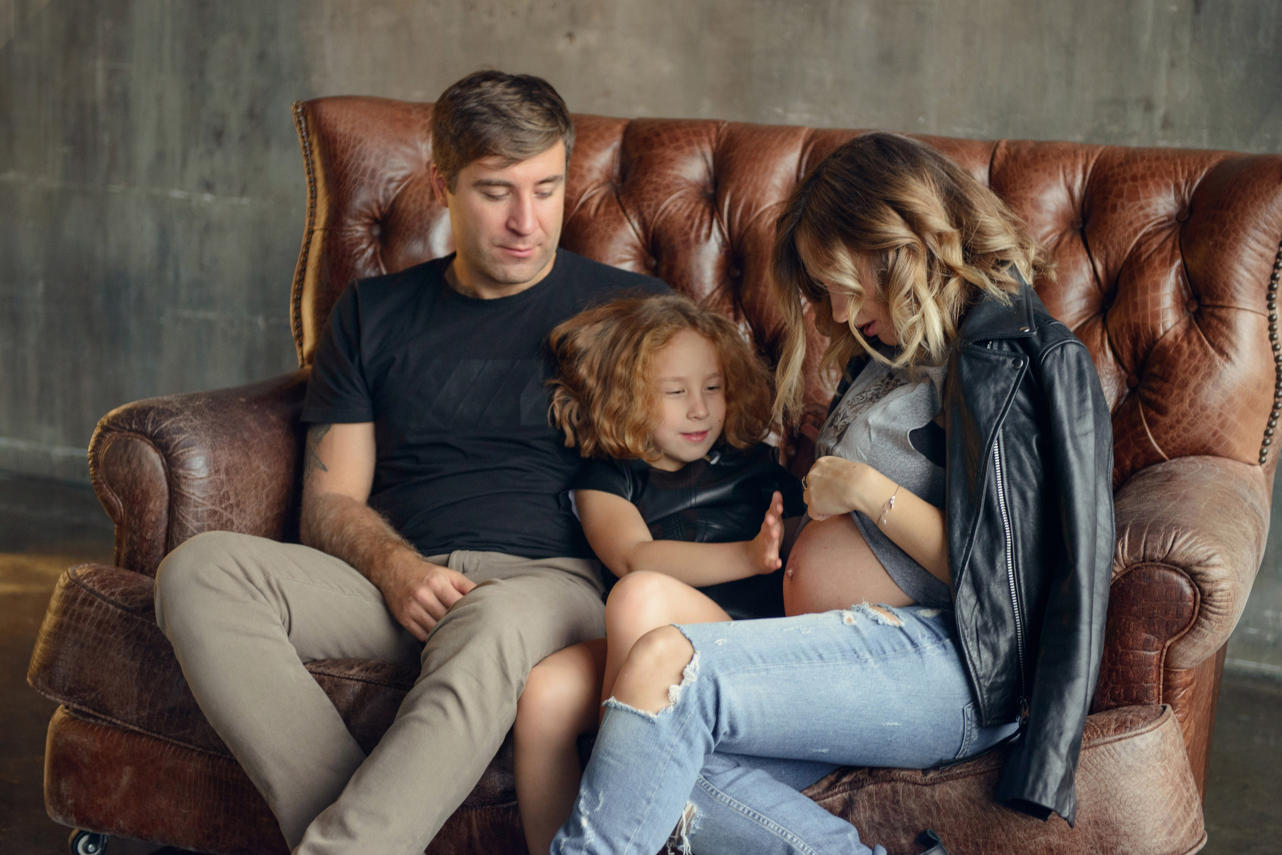 Family photo shoot with a pregnant woman in a loft studio, rock and roll style