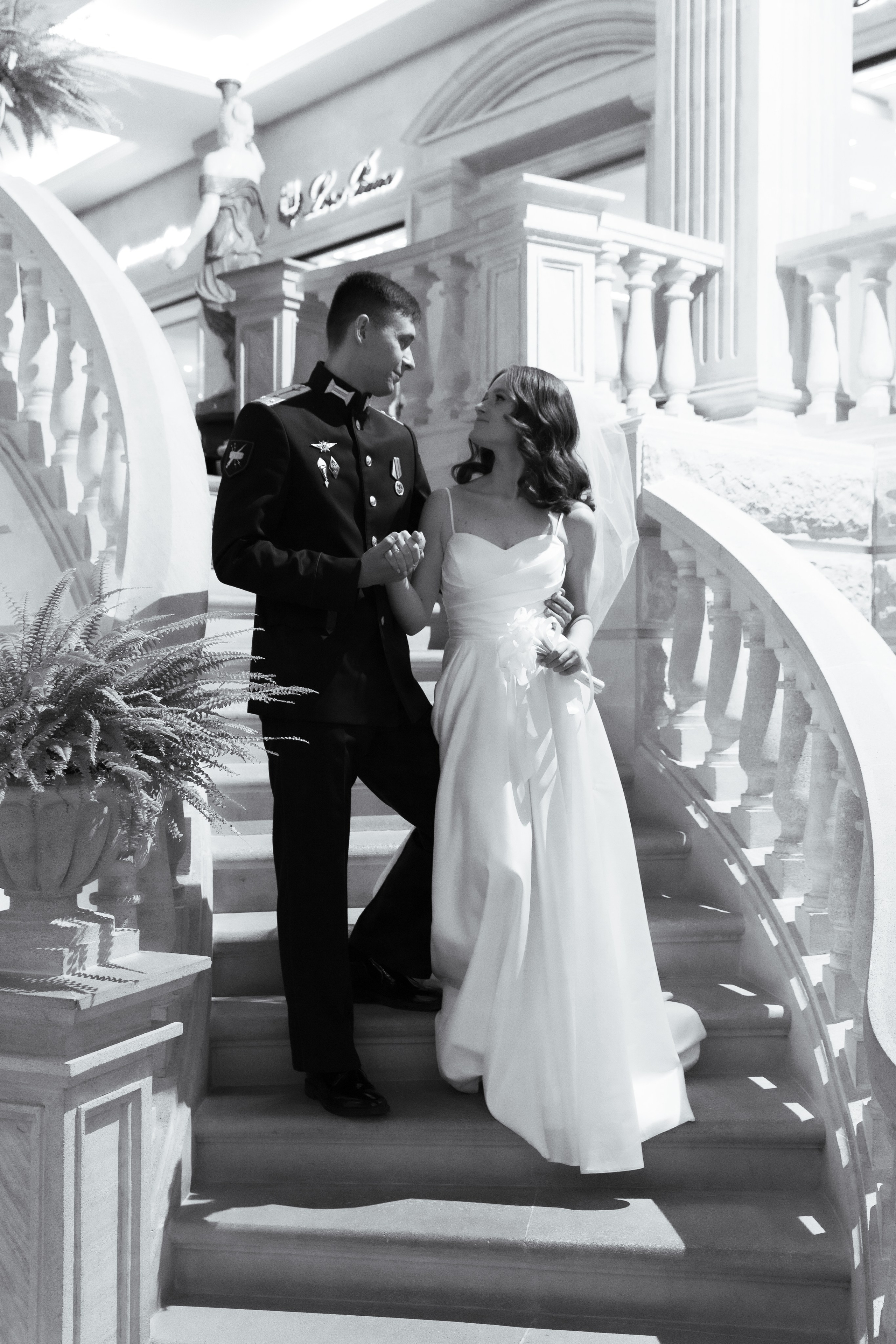 черно белая фотография где жених с невестой спускаются с лестницы 