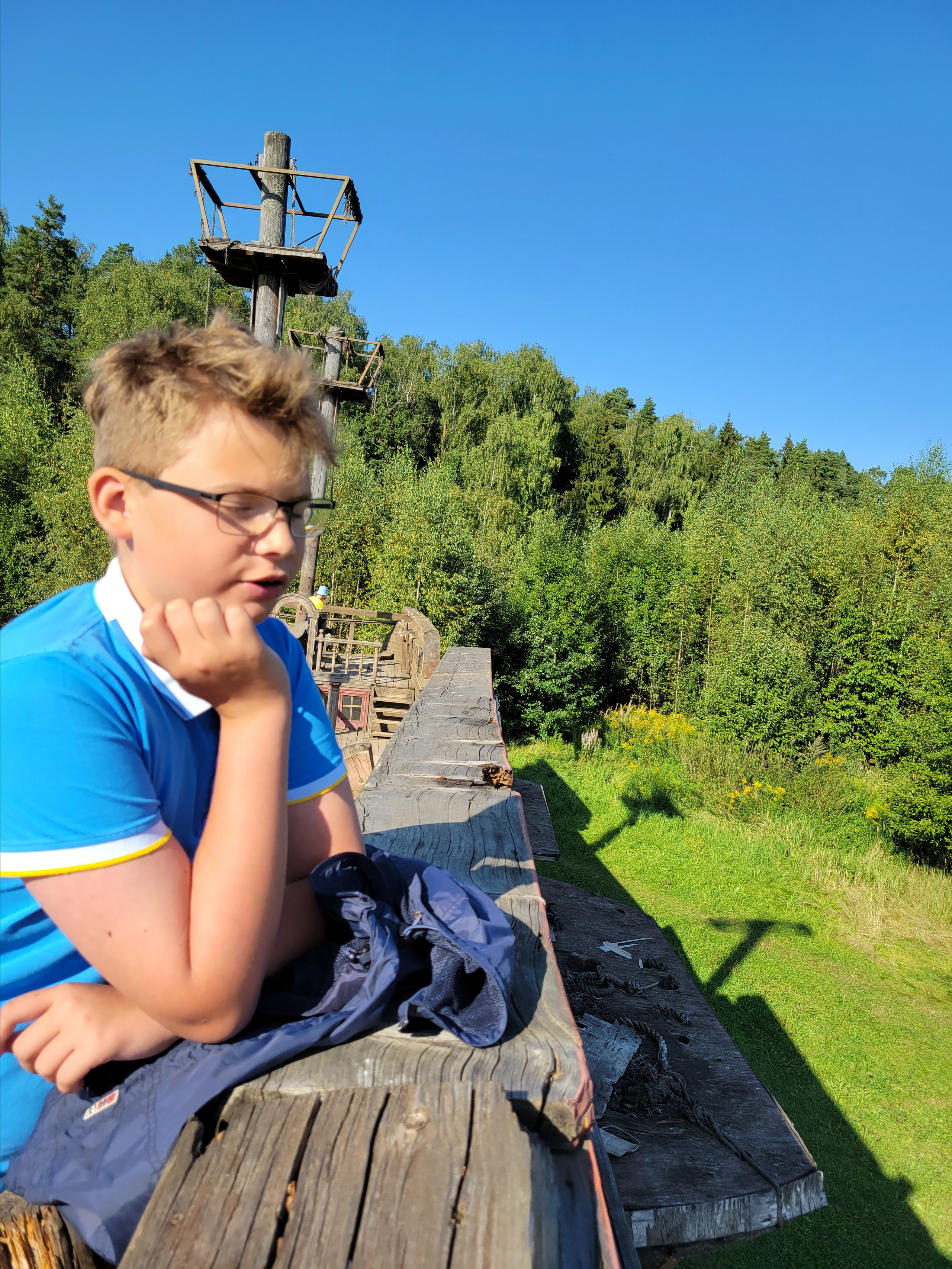 Корабль стоит на краю поля, возле леса, как у причала зеленого моря 