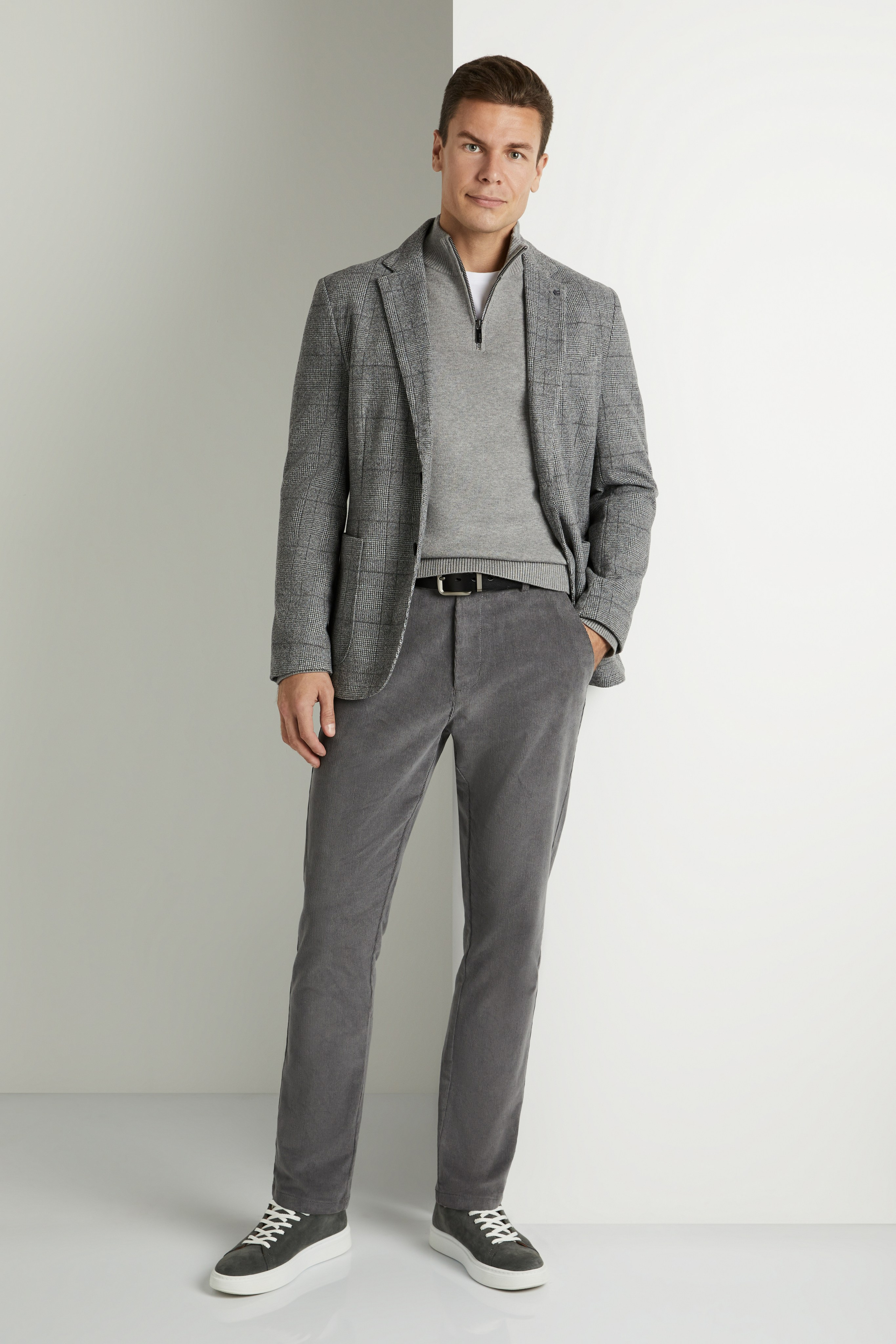 Мужчина модель в сером клетчатом пиджаке и брюках