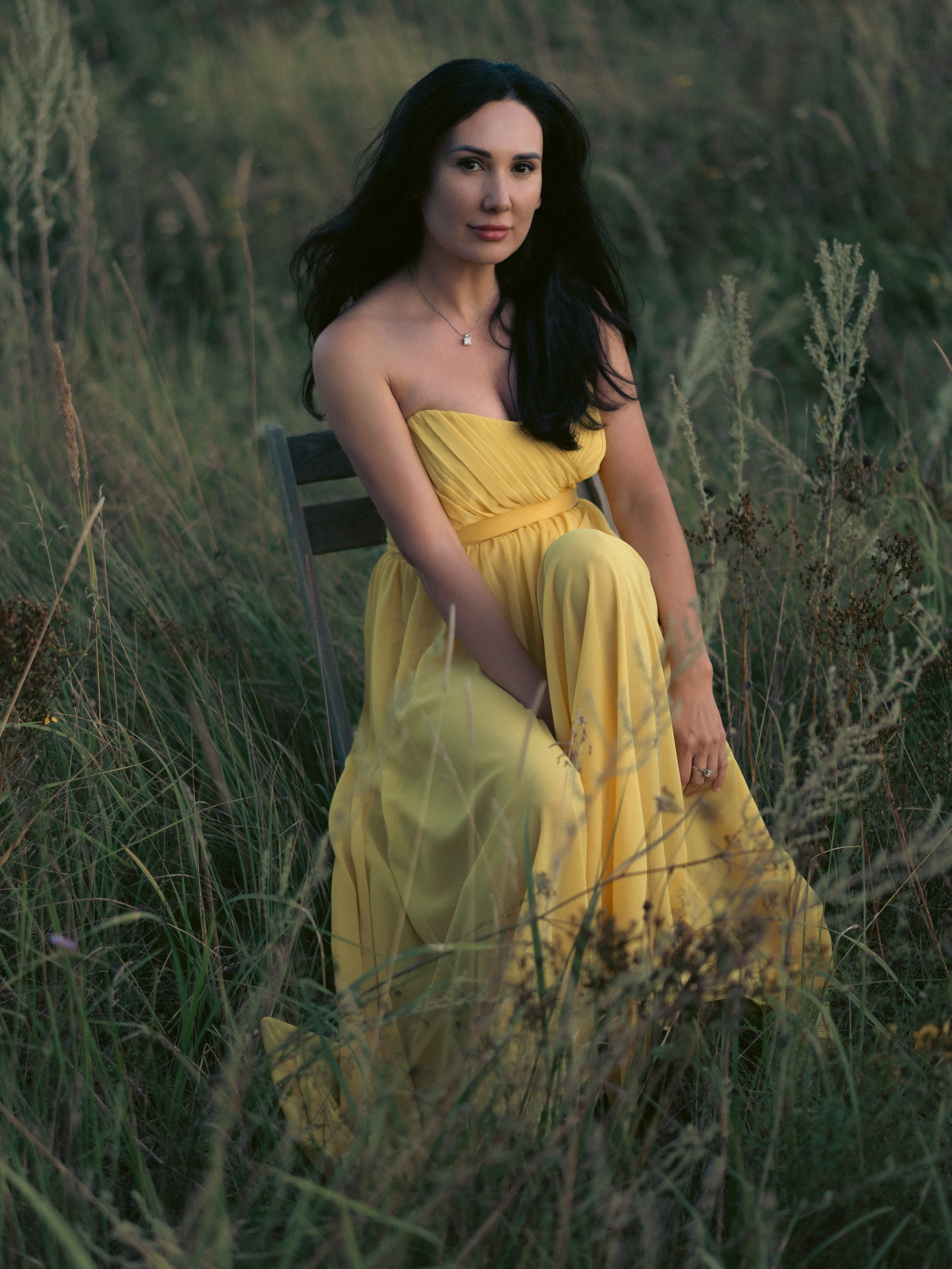 Женственная фотосессия девушки в лёгком развевающемся платье на поле в траве