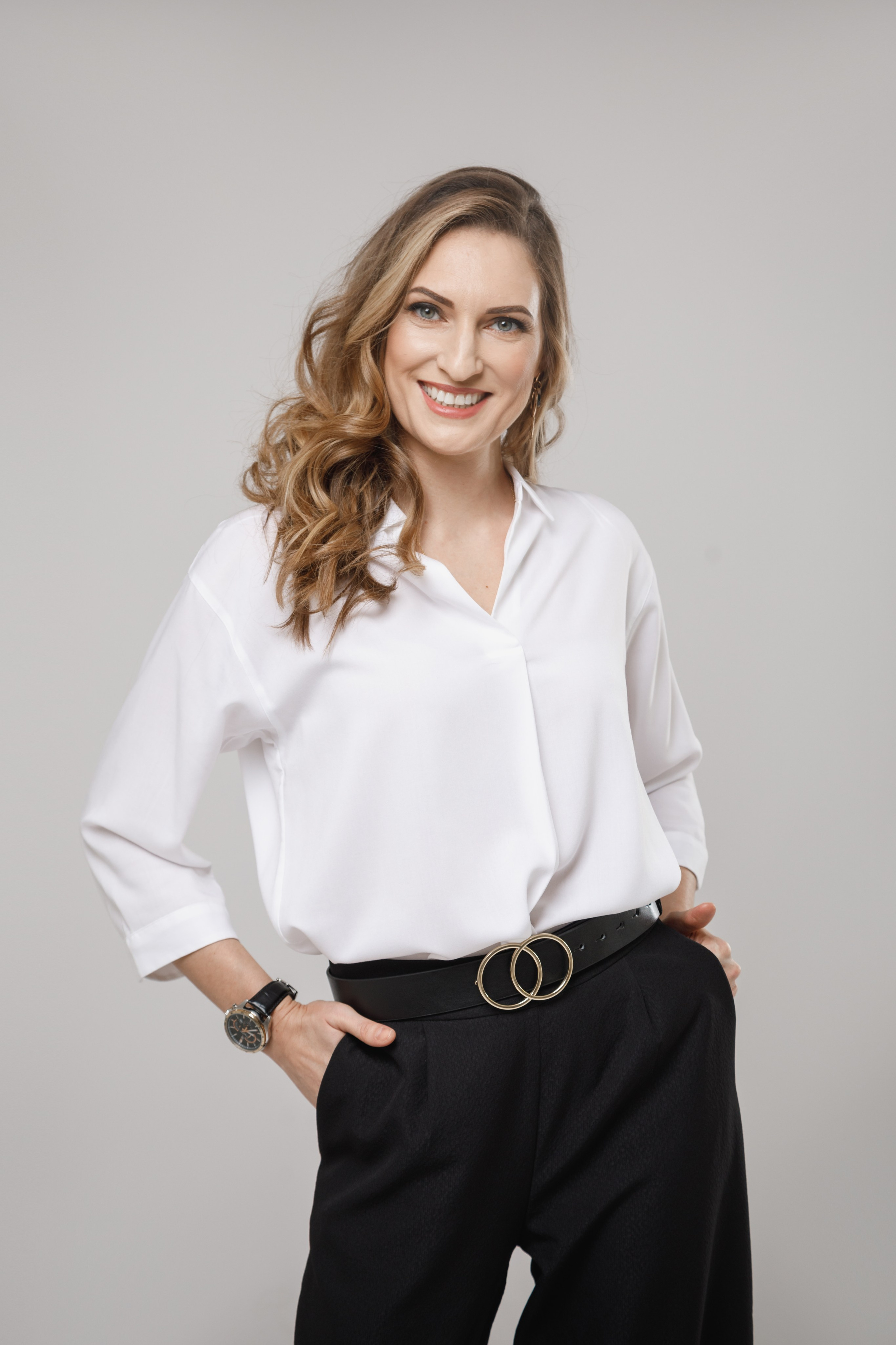Деловой портрет девушки в белой рубашке на нейтральном однотонном фоне.