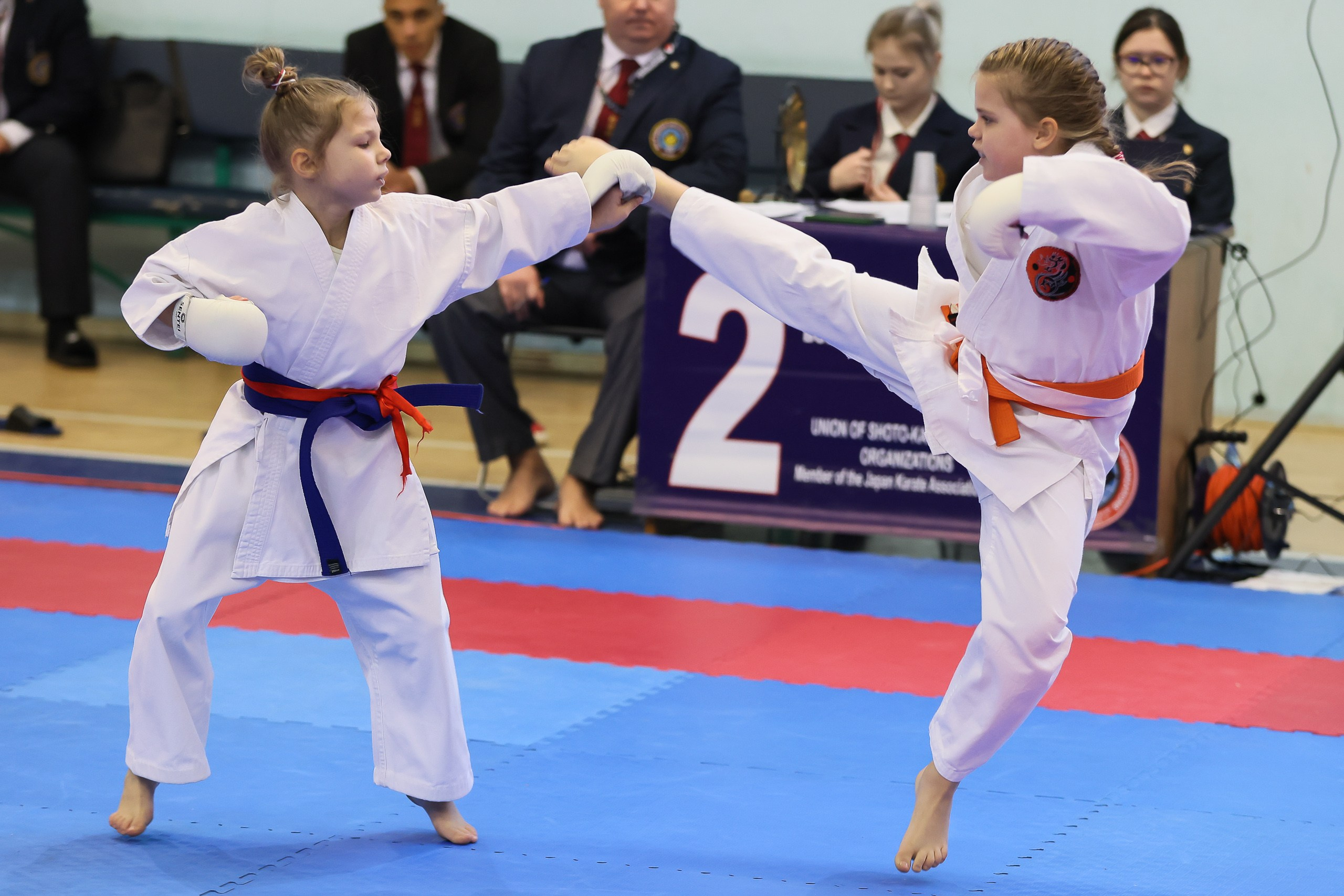 Девочка карате наносит удар ногой