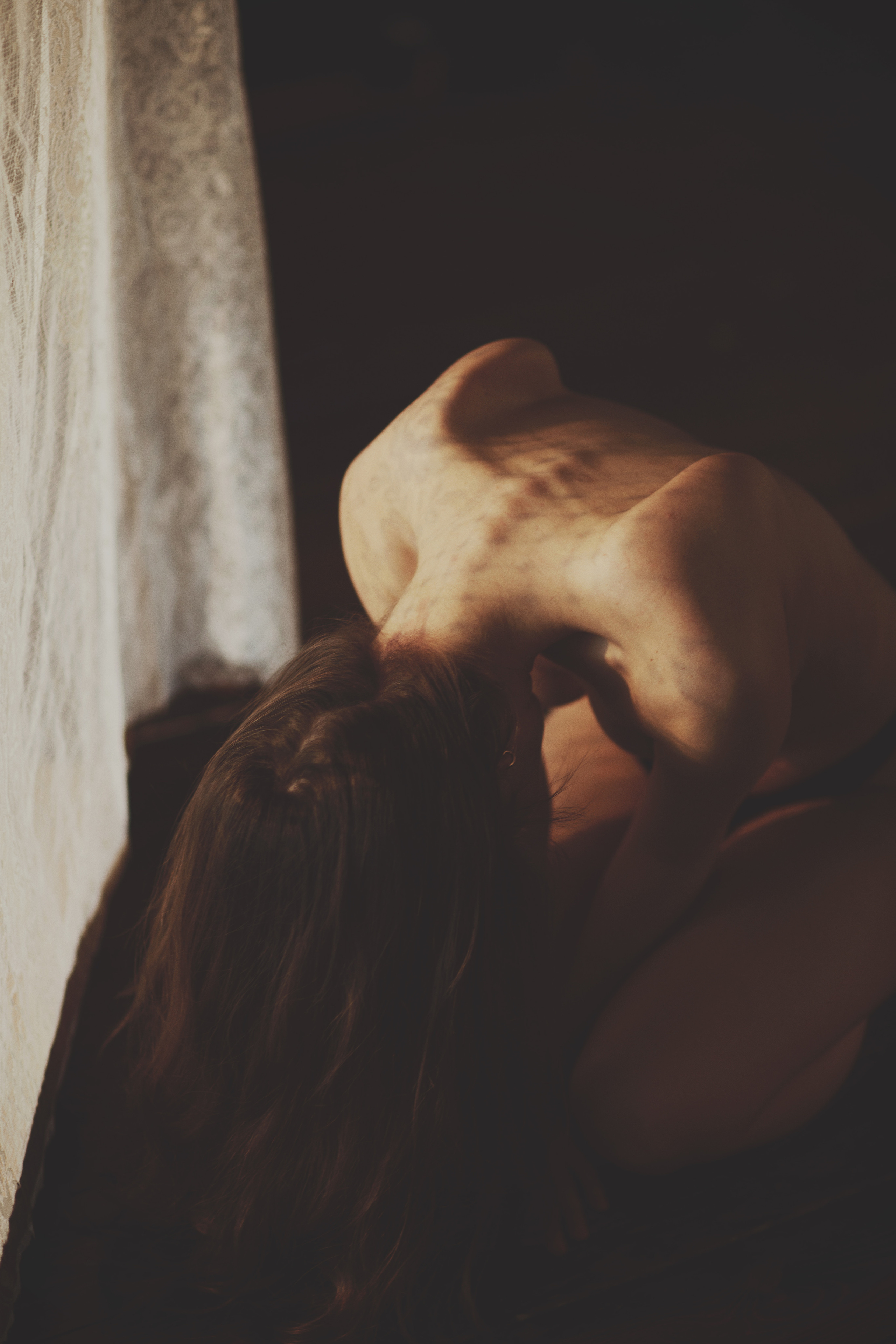 Фотосессия ню, женская спина, свисающие волосы, лопатки, фон занавески