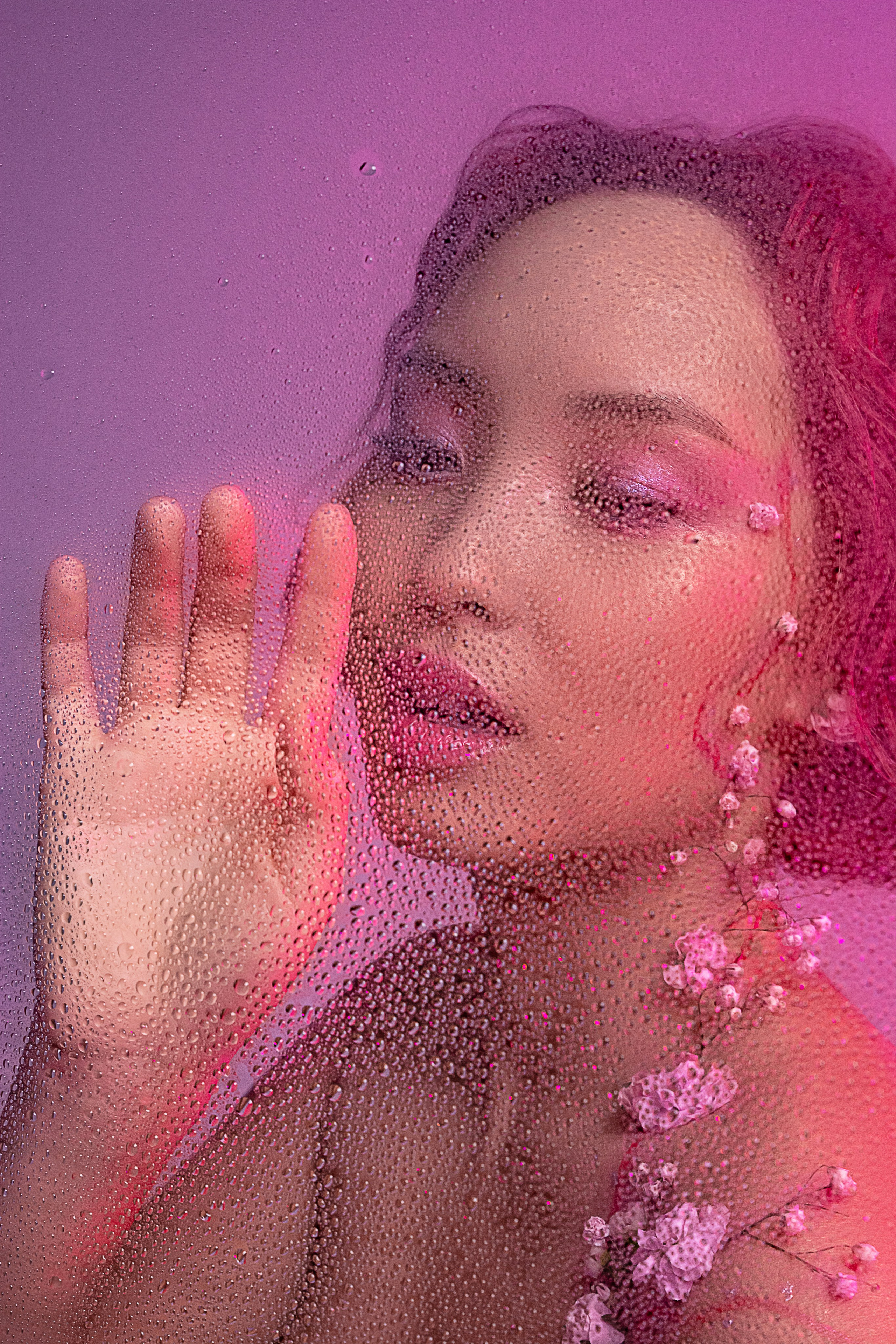 Чувственный образ юной азиатки, чье тело декорировано живыми цветами, ее задумчивый взгляд направлен на капли, стекающие по запотевшему стеклу, предвещая весеннее возрождение.