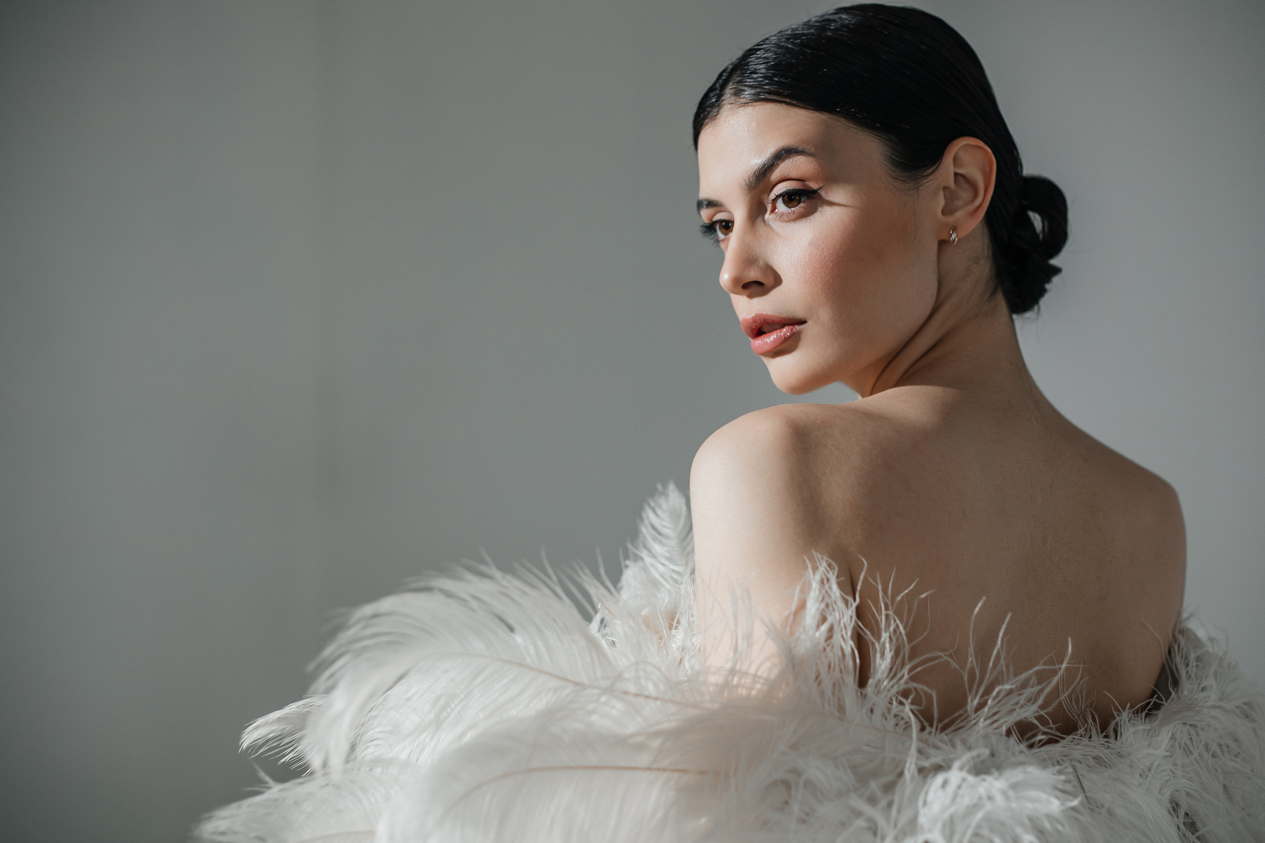Фотосессия в перьях на белой циклораме в студии
