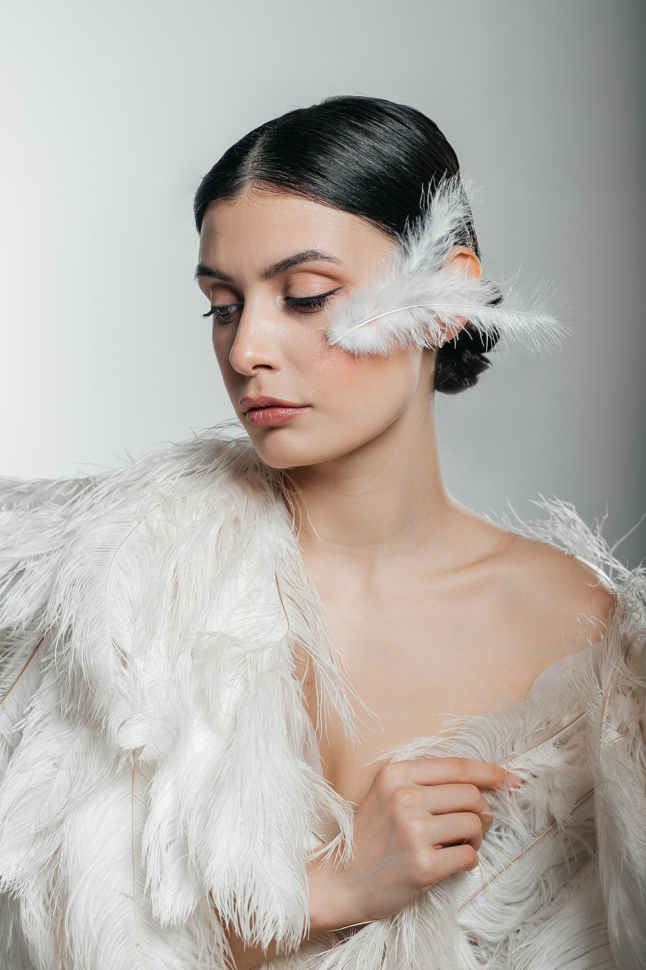 Фотосессия в перьях на белой циклораме в студии