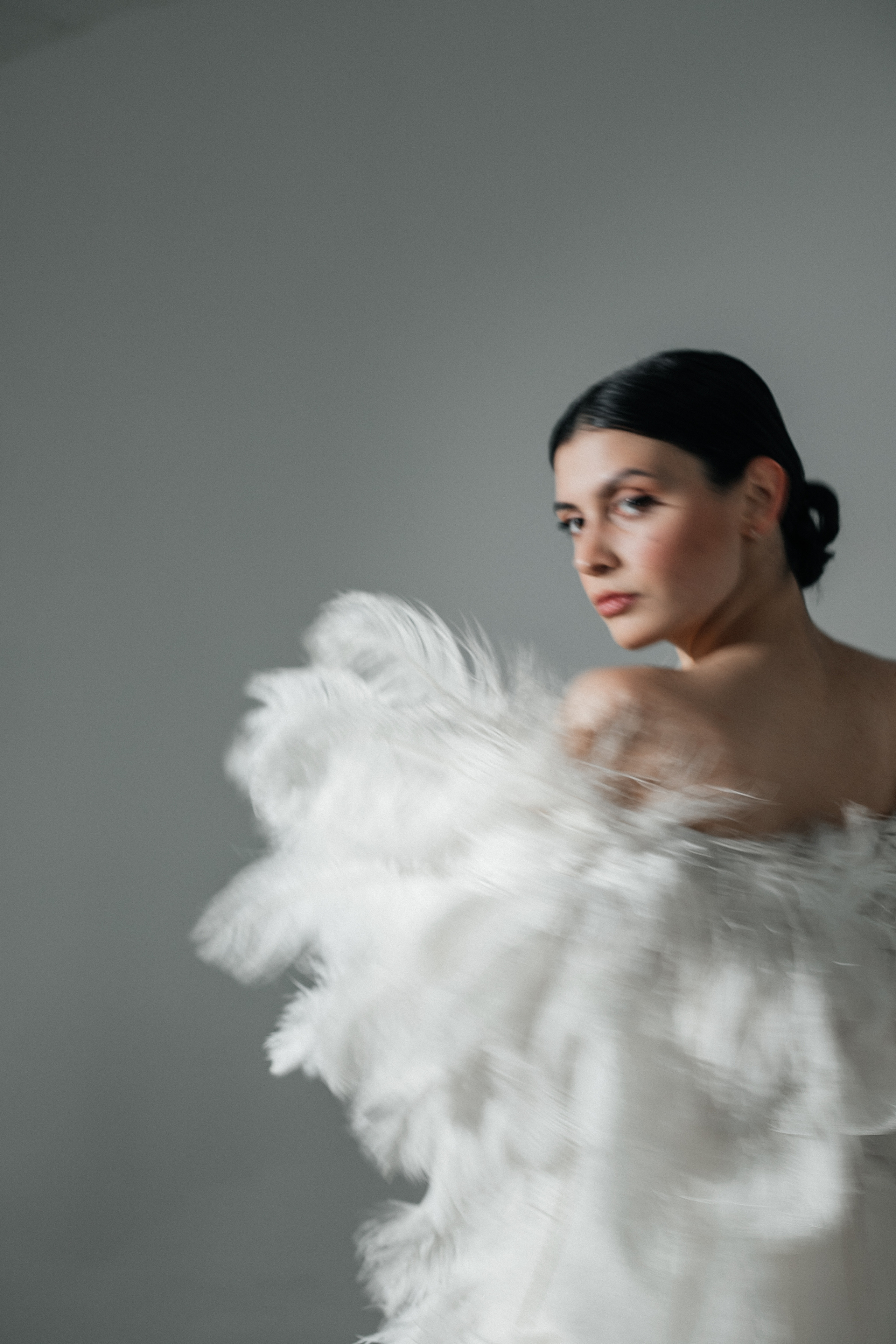 Фотосессия в перьях на белой циклораме в студии