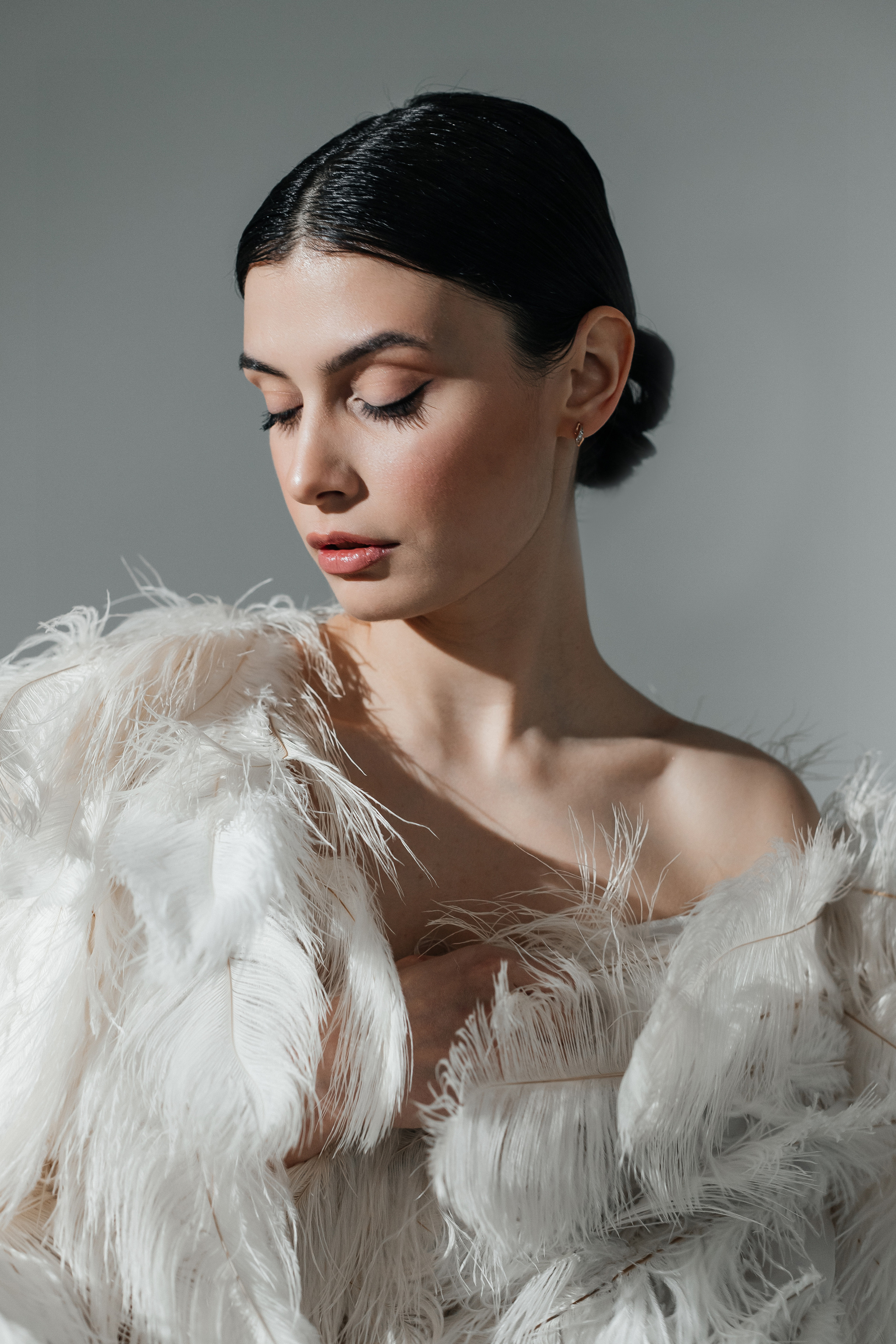 Фотосессия в перьях на белой циклораме в студии