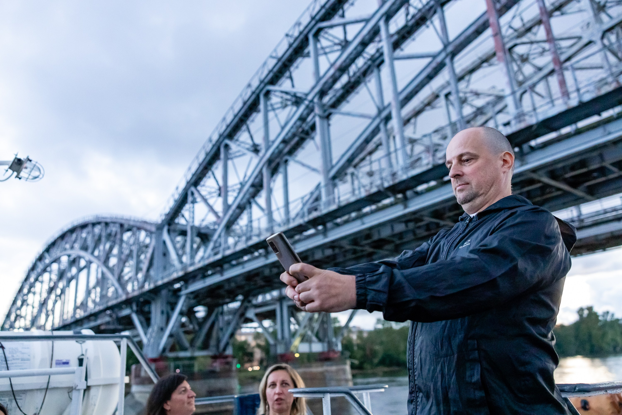 Мужчина делает селфи на фоне моста с теплохода на Неве