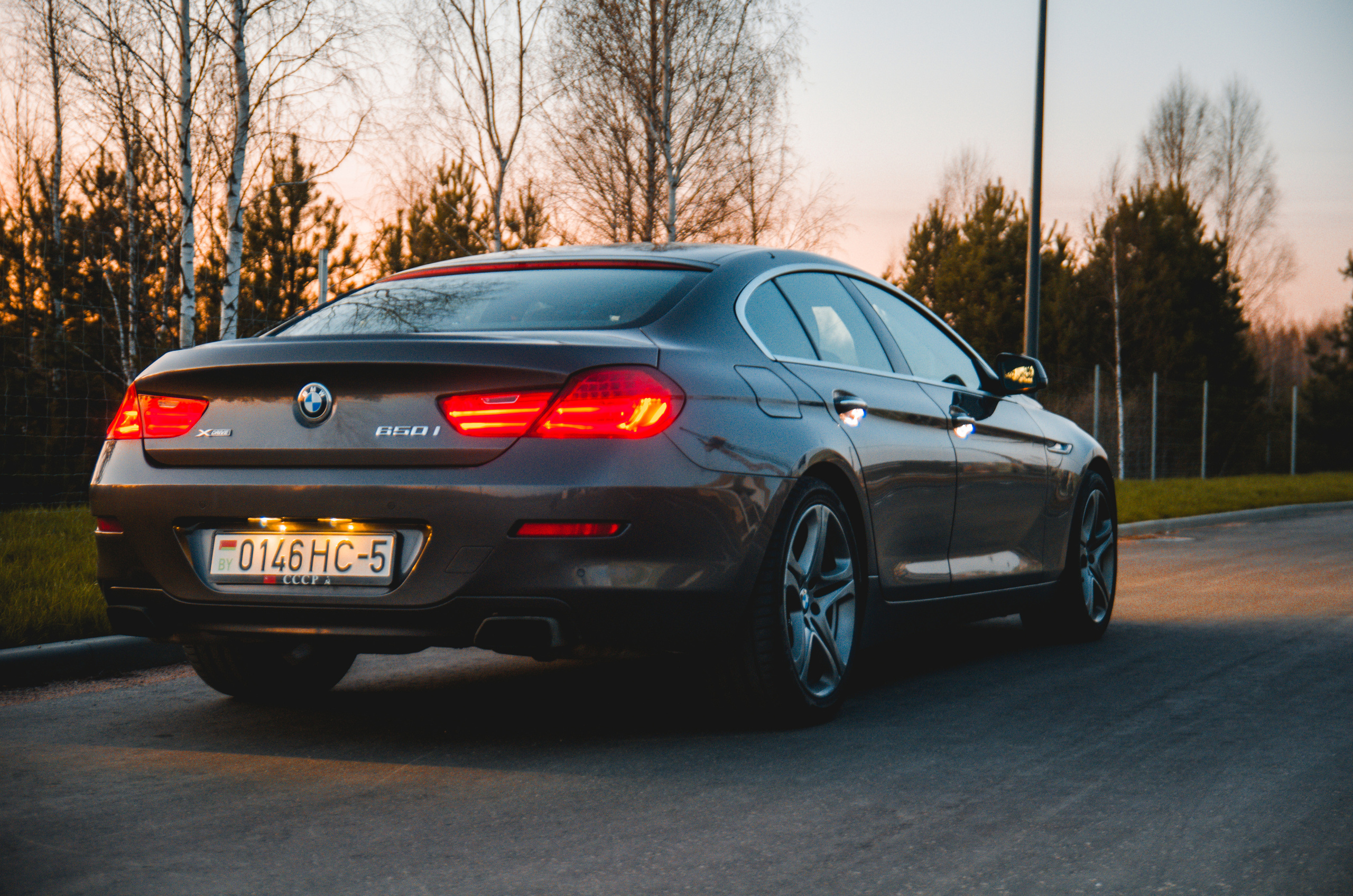 Коричневая BMW 650i xDrive вечером, вид сзади