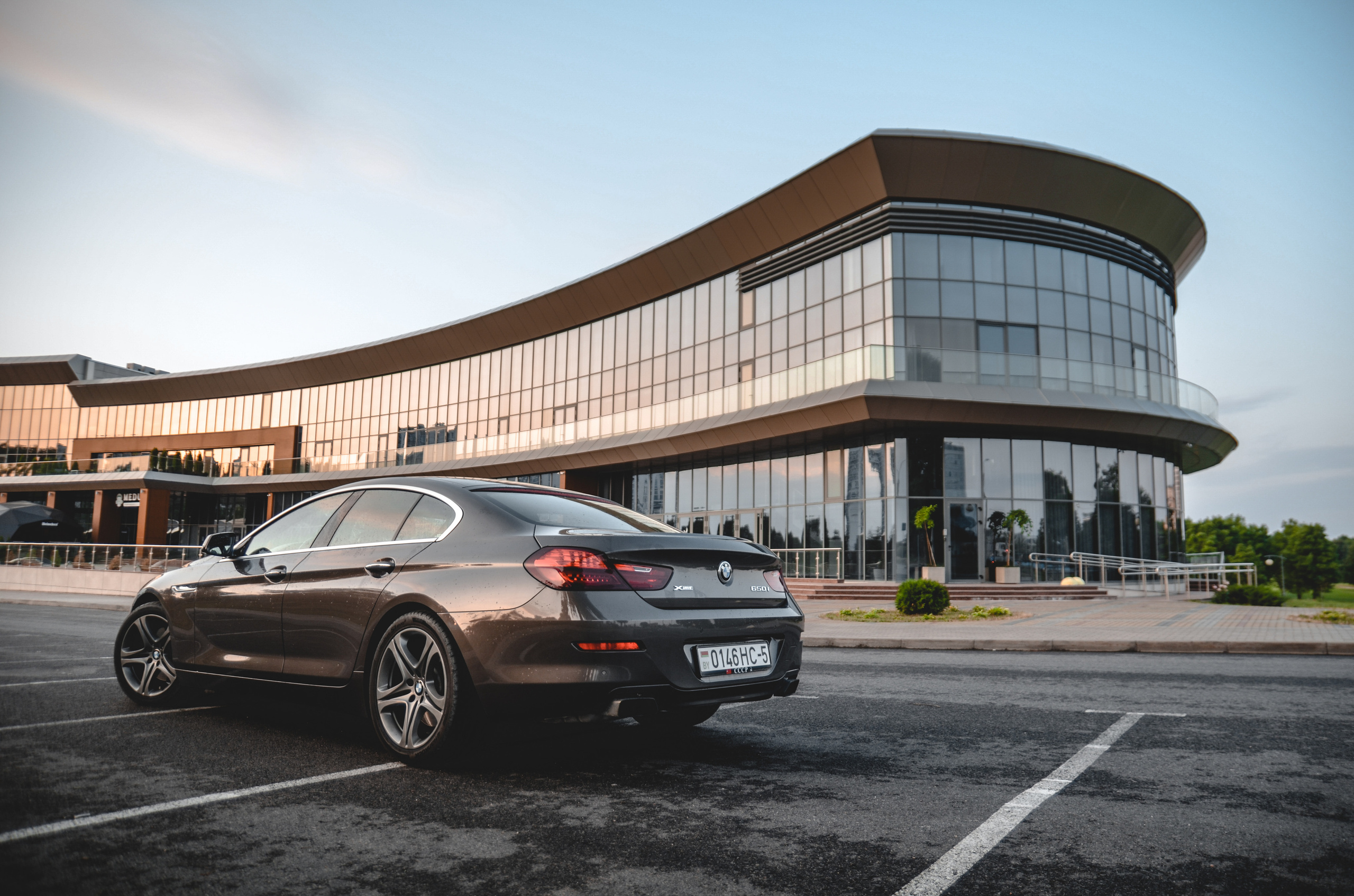 Коричневая BMW 650i xDrive на фоне здания, Минск