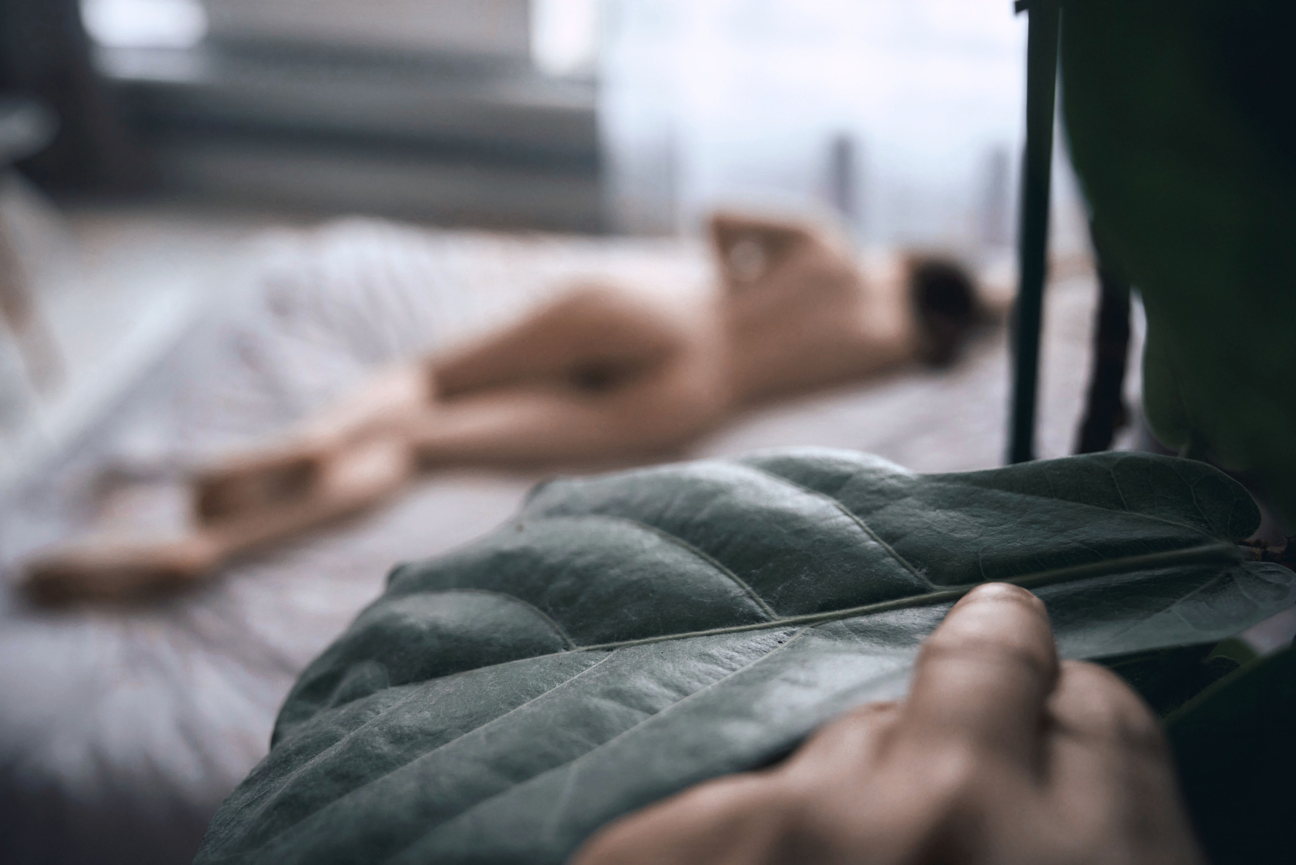 фотограф подглядывает за моделью в студии во время фотосессии ню