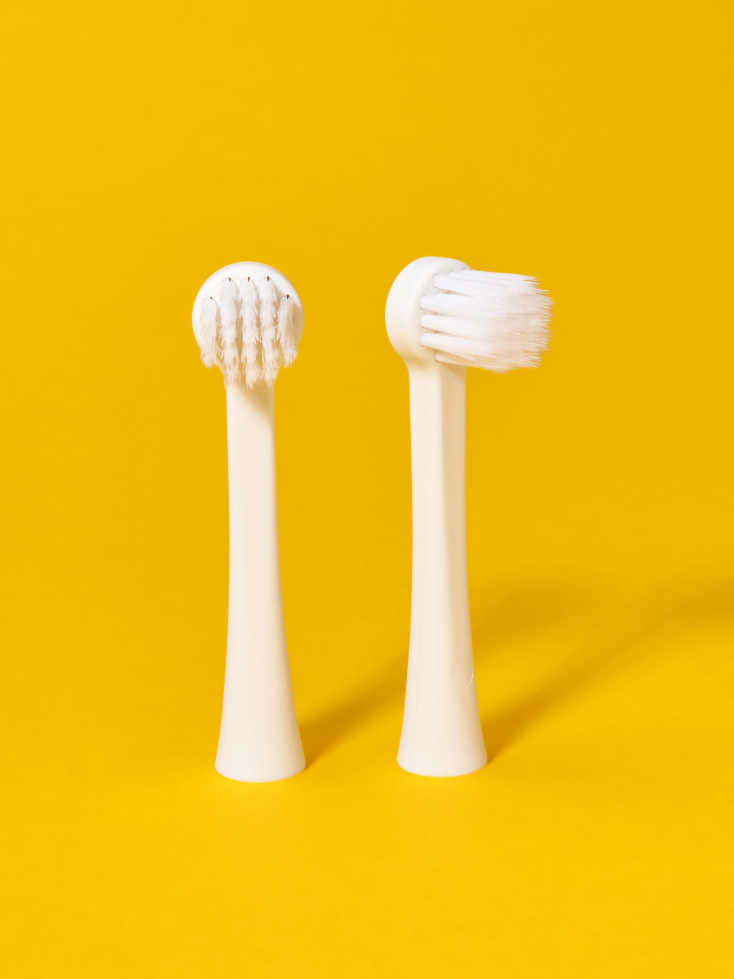 Предметная фотосъёмка детской зубной щетки на желтом фоне