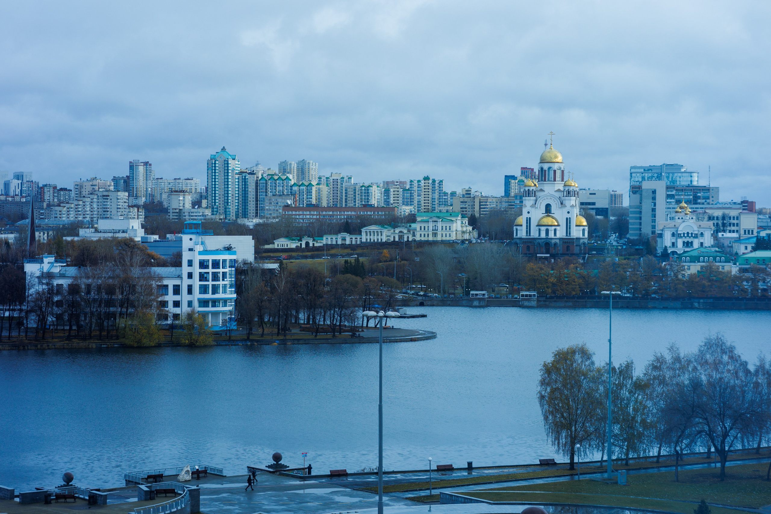 Современный стеклянный небоскреб, отражающий облака. Вертикаль города и прозрачность материалов.