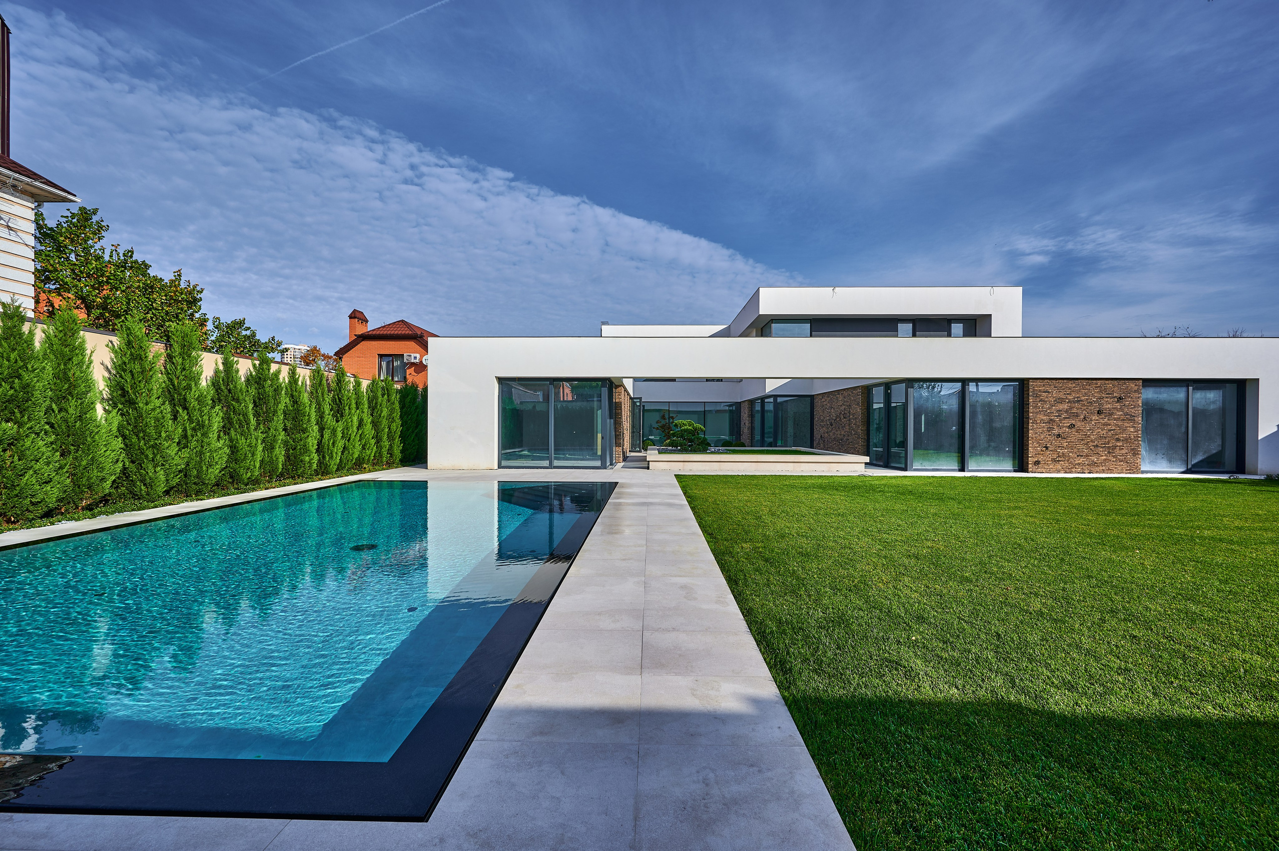 хайтек дом с бирюзовым бассейном и зеленым газоном