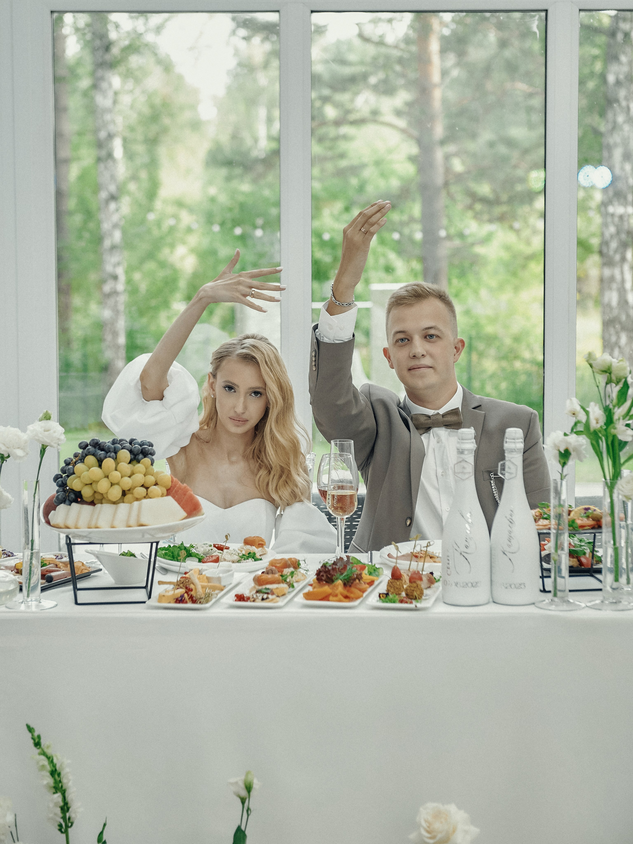 Свадебный банкет в экохаусе на природе — жених и невеста за праздничным столом.