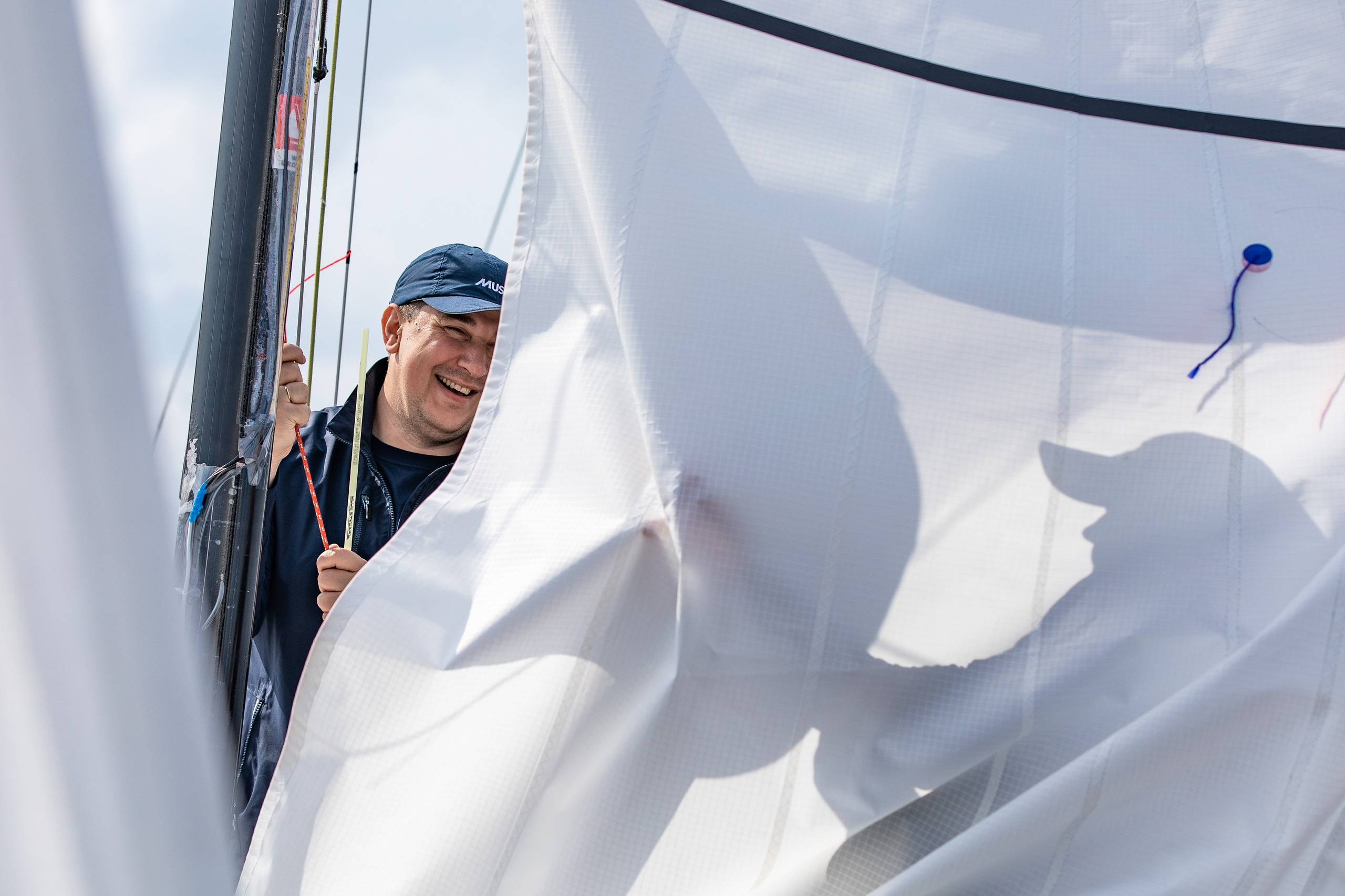 Яхтсмен вооружает яхту. Тень на парусе.