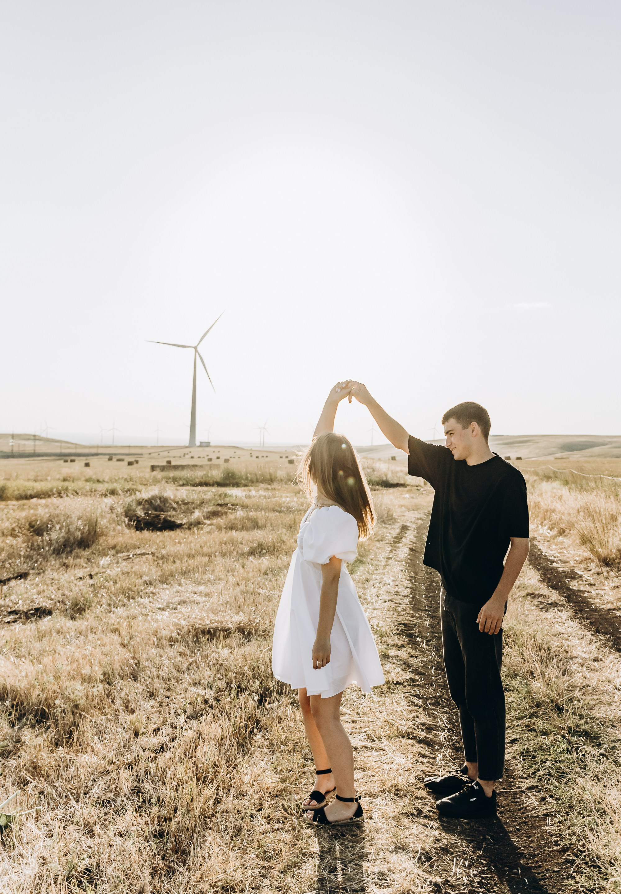 Романтический вечер в парке, двое влюбленных держатся за руки под закатом