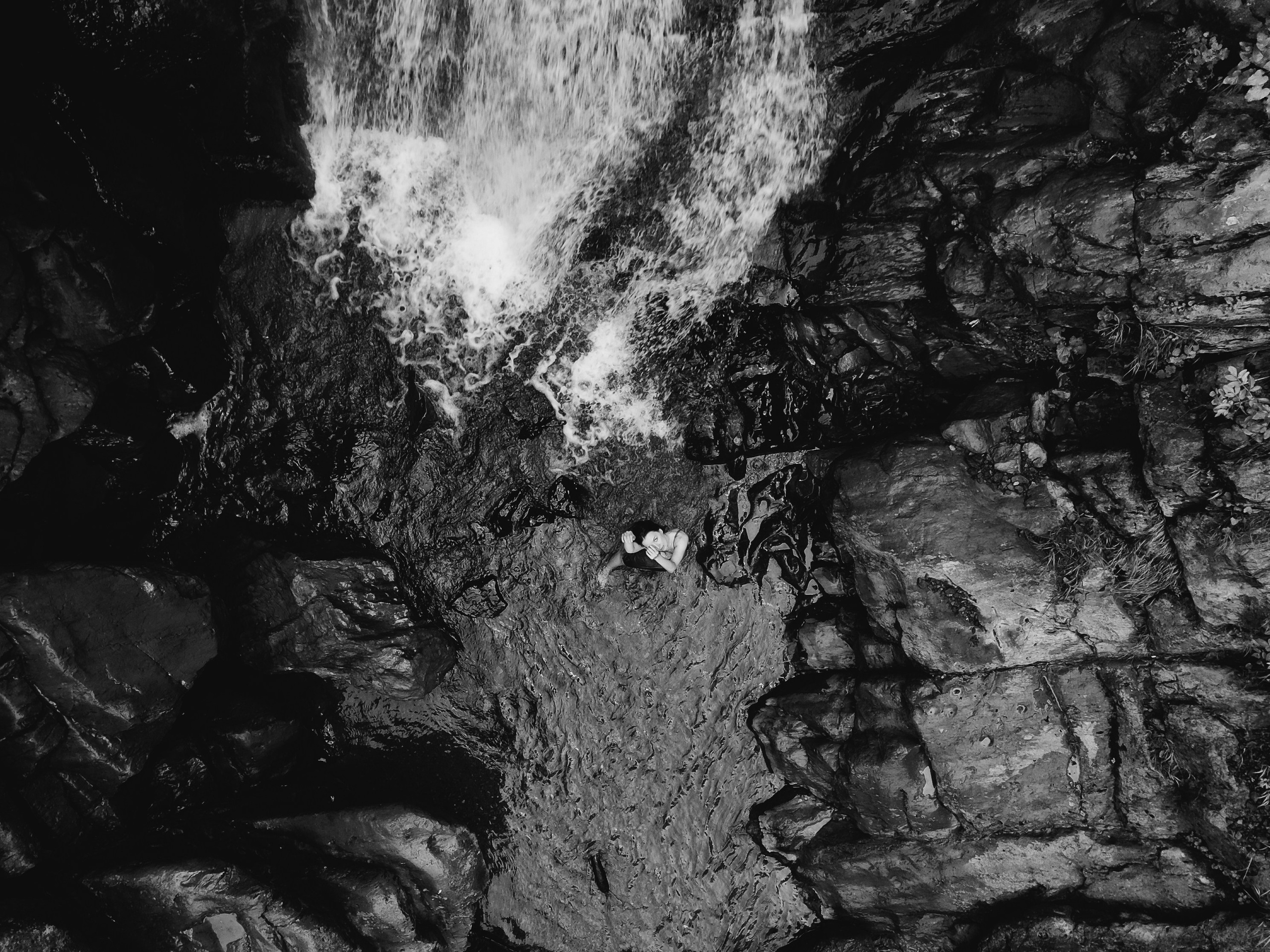 Фотография с коптера сверху девушки и водопада 