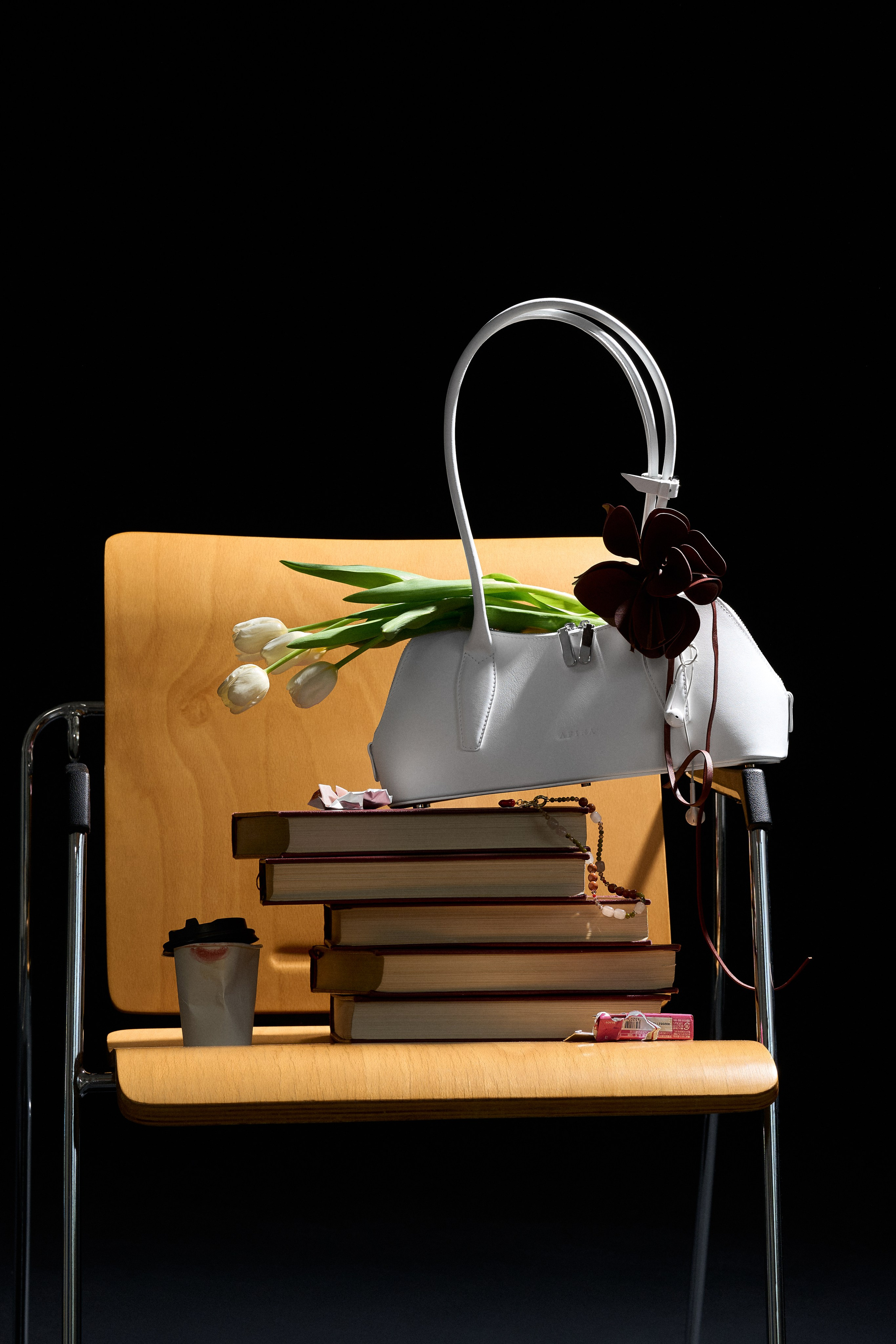 Кожаная сумка Afina Bags в предметной композиции с книгами и цветами