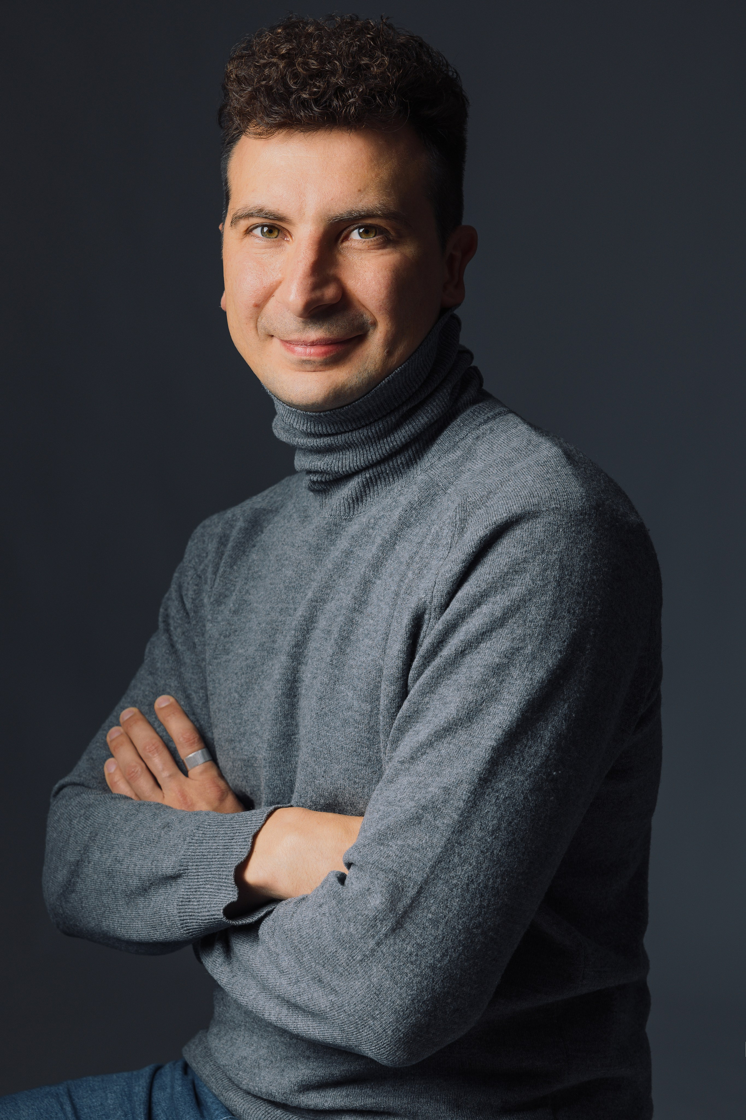 Портрет мужчины в серой водолазке в студии