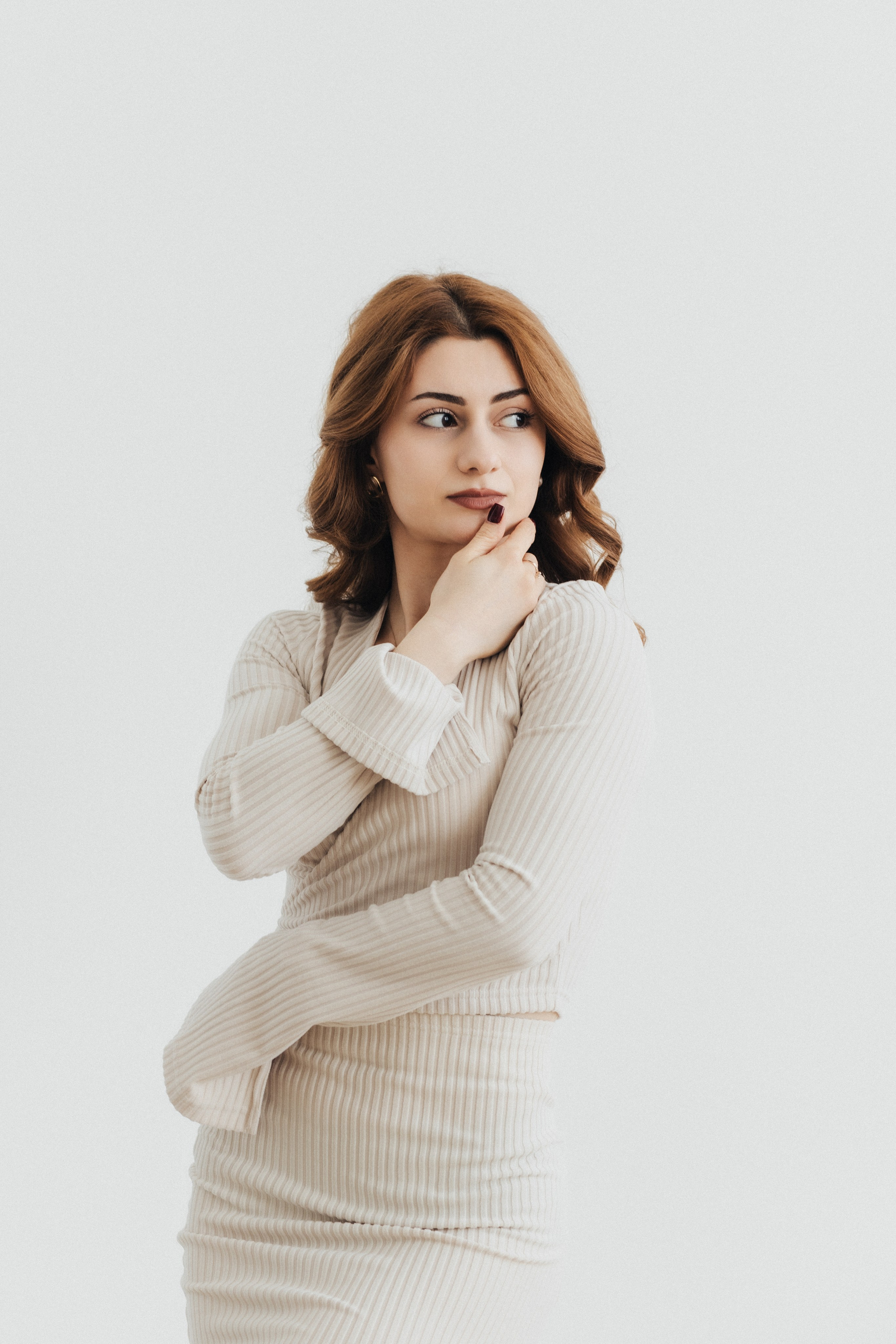 Девушка в бежевом трикотажном костюме, элегантная поза, светлый минималистичный фон. Фотограф в Пензе Александра Овечкина