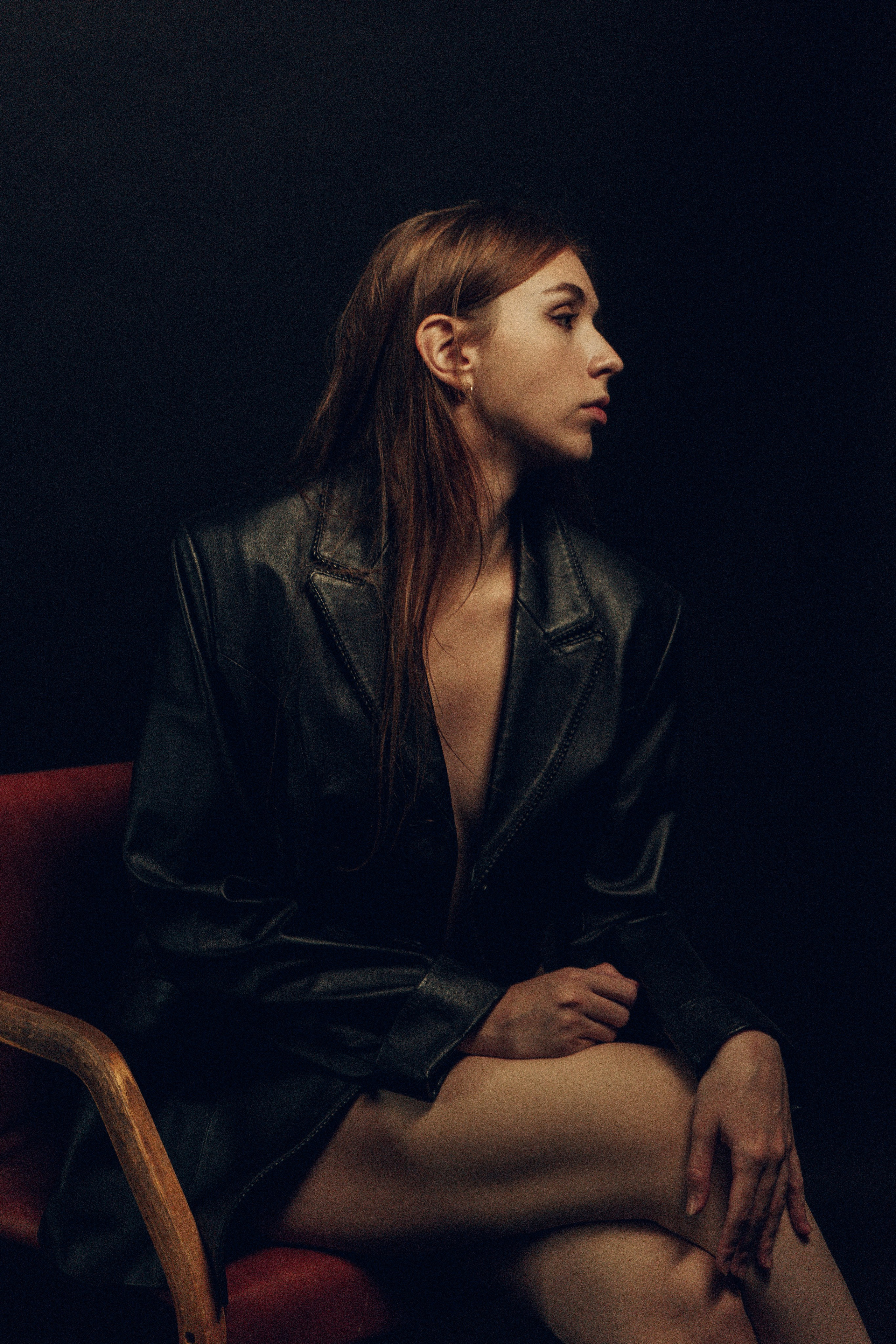 Девушка в чёрном пиджаке сидит на стуле