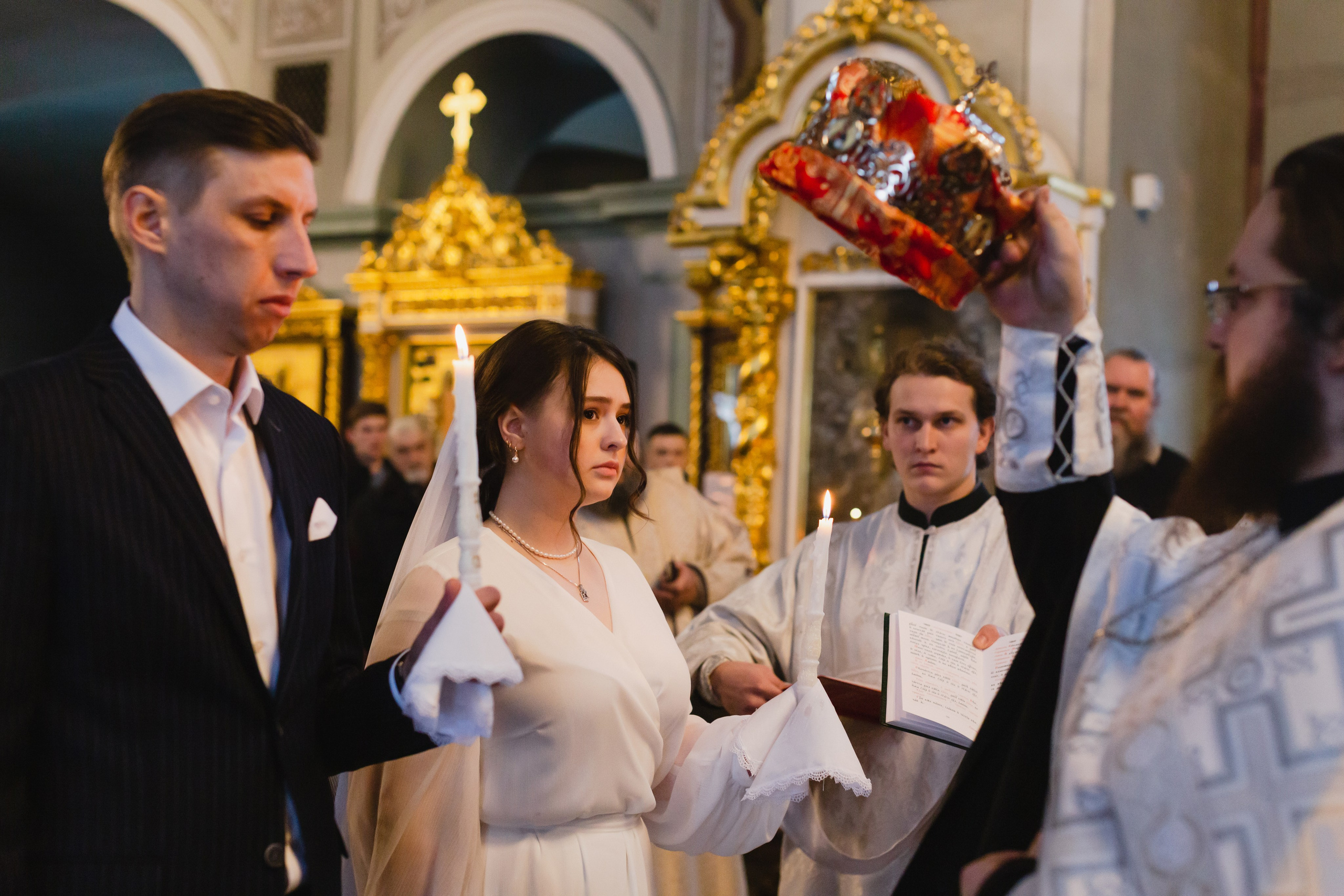 Священник возлагает венцы на венчающихся. 