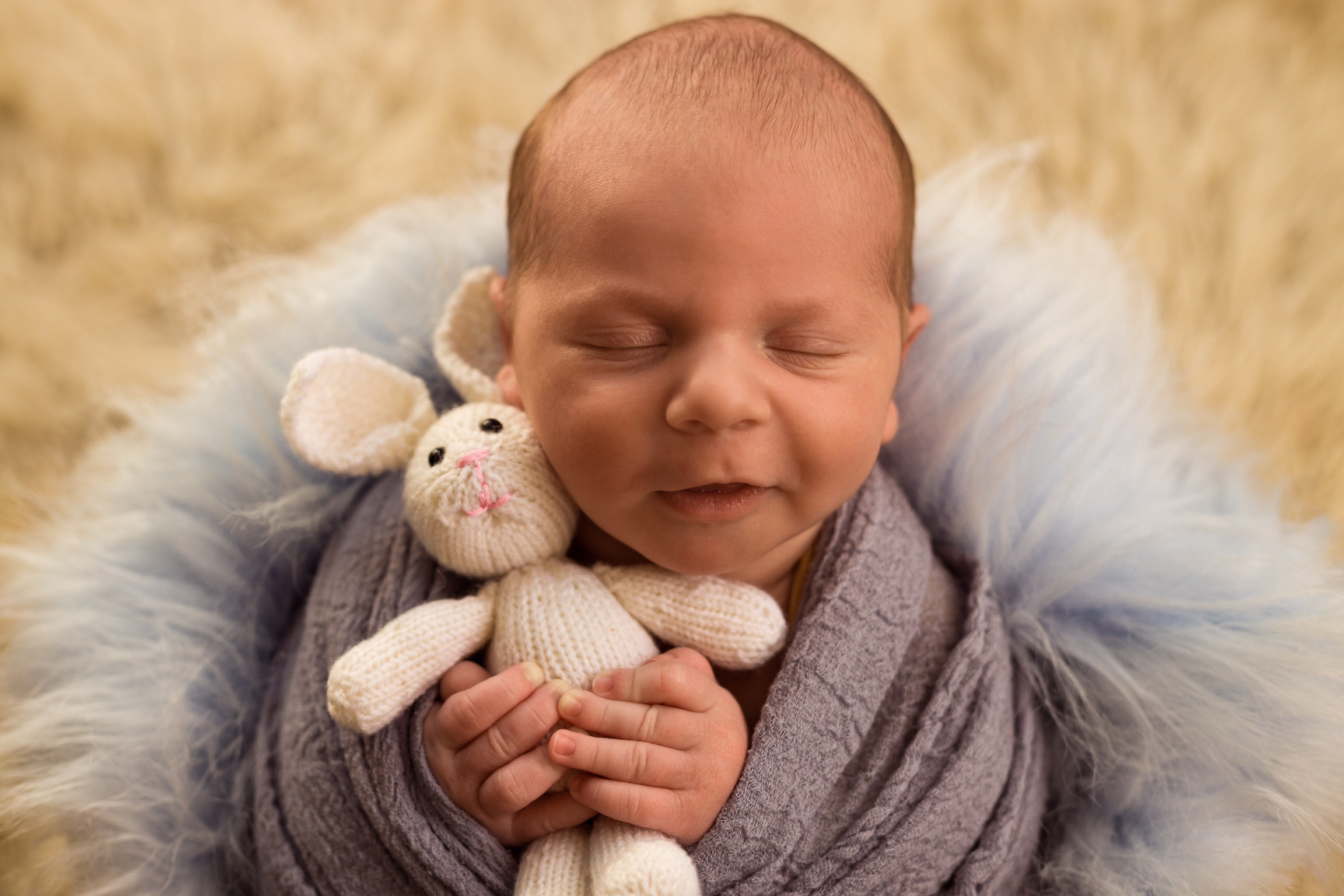 мальчик в коконе с игрушкой на голубом меху