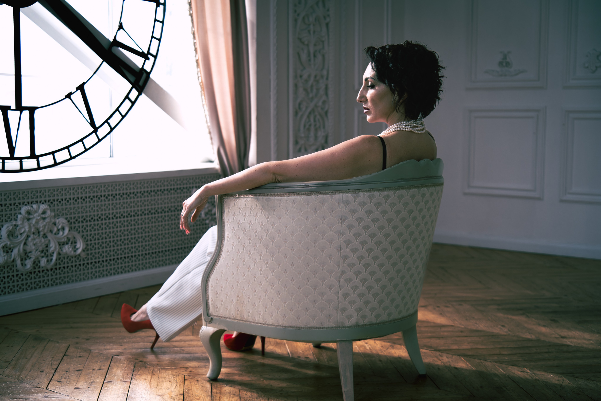 Фотография, сделанная во время профессиональной фотосессии. На ней изображена модель или группа людей в студии или на открытом воздухе. В кадре присутствуют студийное освещение и реквизит.