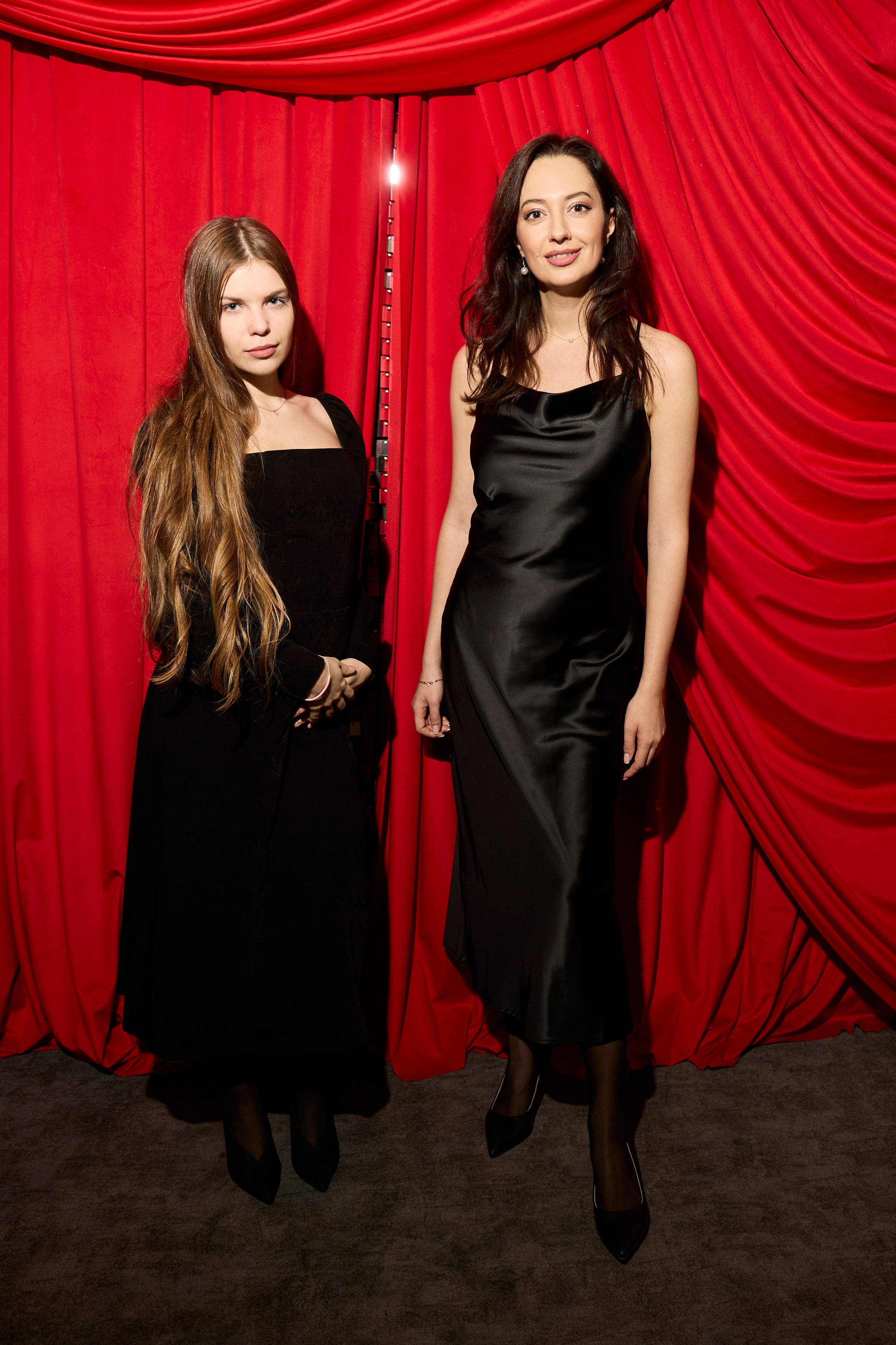 Фото двух коллег в черных платьях на корпоративе в Москве.