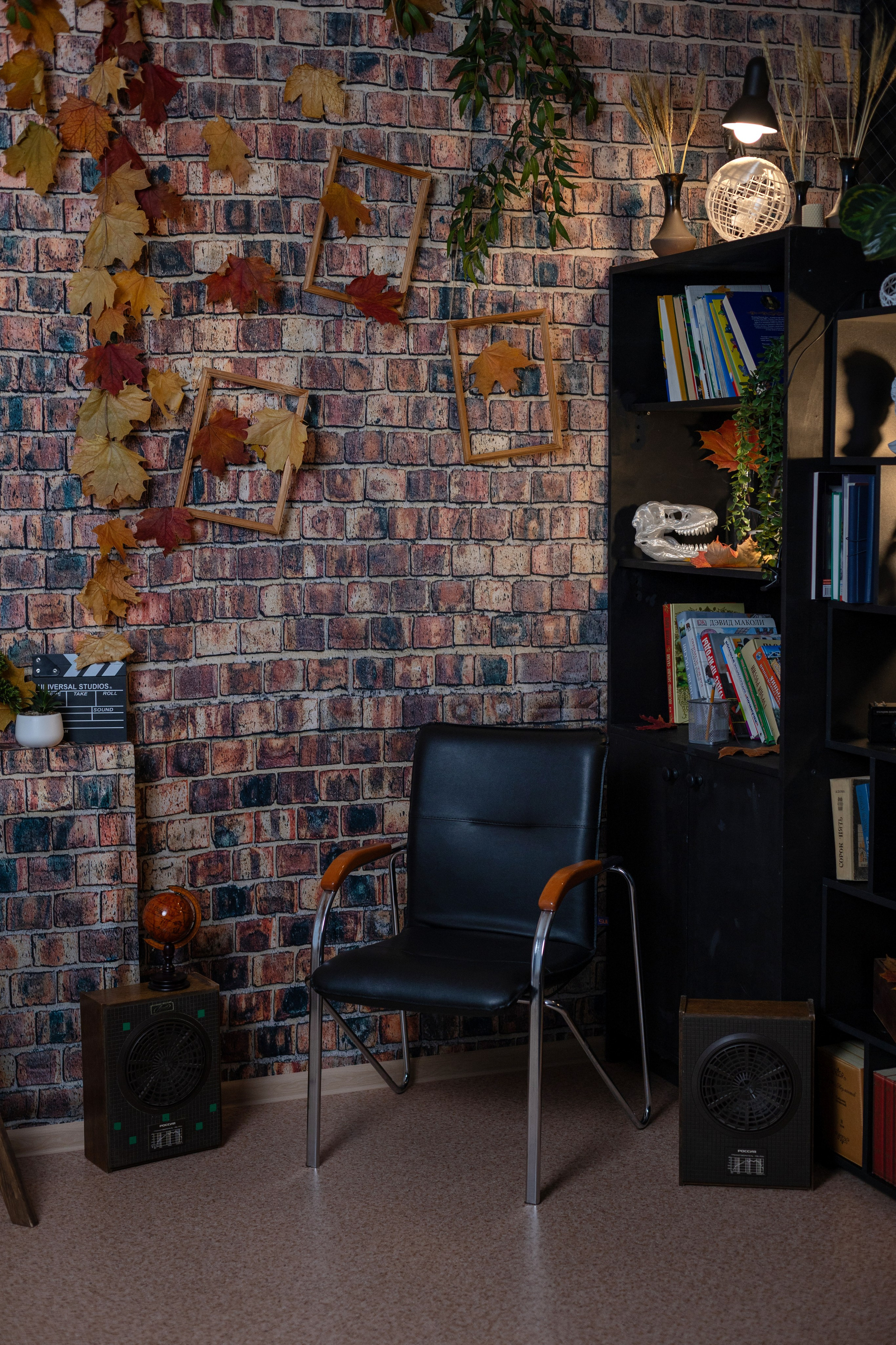 Уголок фотопроекта «Школьные истории — 2026» с креслом, кирпичной стеной и осенними листьями