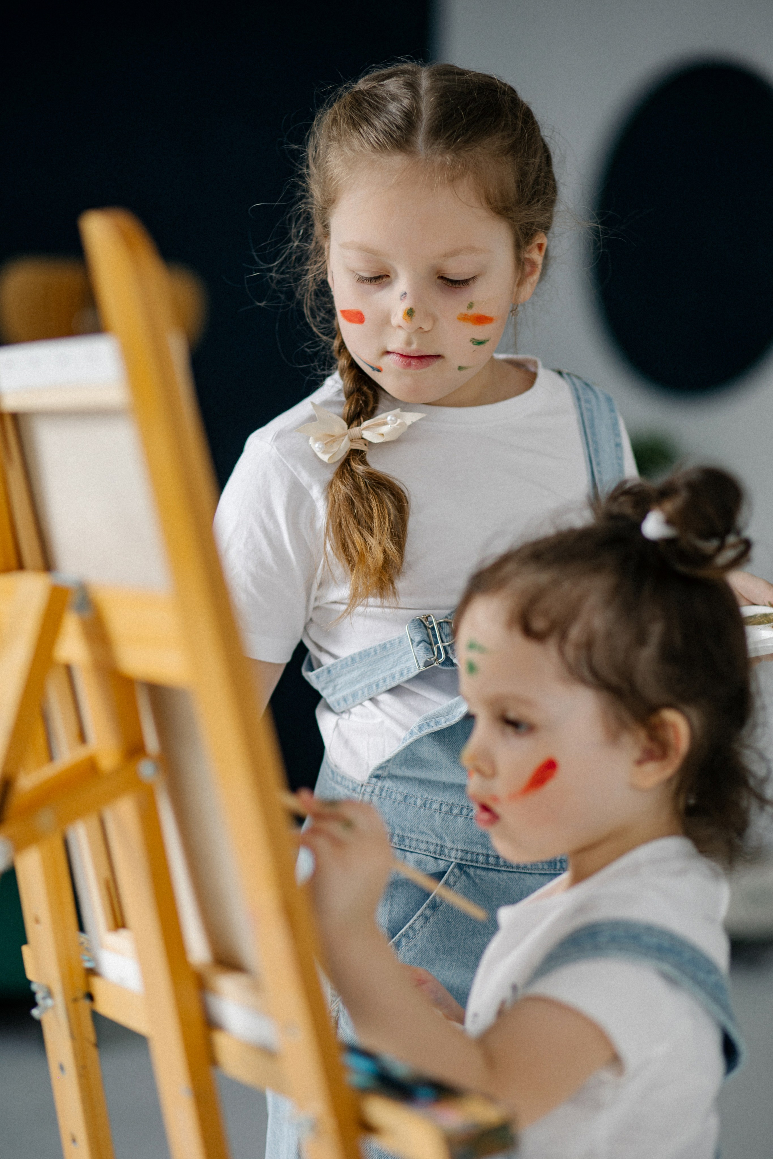 Щедрый всплеск красок на детском лице отражает неподдельную радость от совместной игры двух сестричек в семье, созданной профессиональным фотографом Алексеем Клещиновым