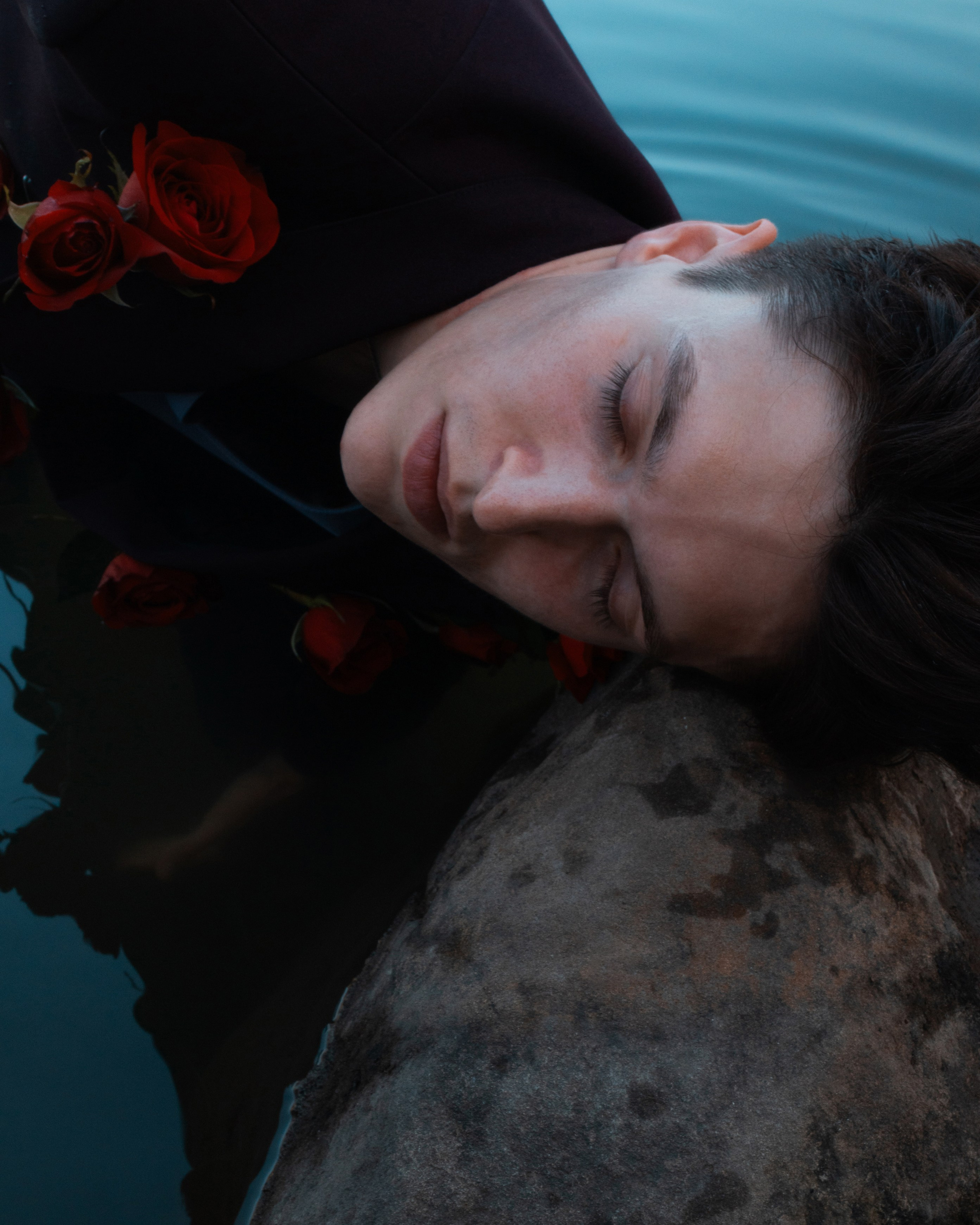 Художественная фотосессия во Владивостоке, крупный портрет парня, голова лежит на камне, парень в костюме, розы, в озере,  фотосессия в воде