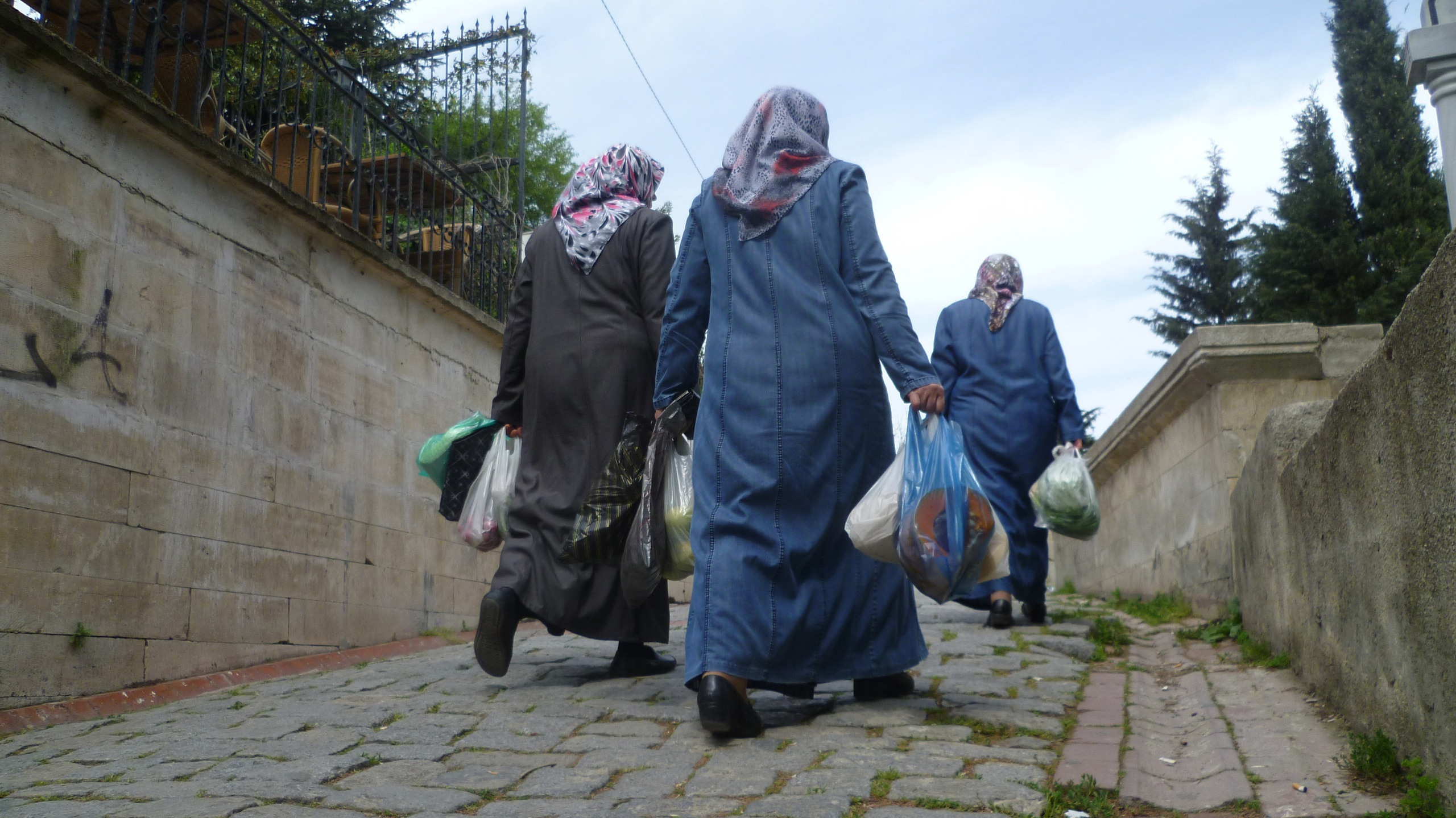Женщины мусульмане идут с пакетами из магазина