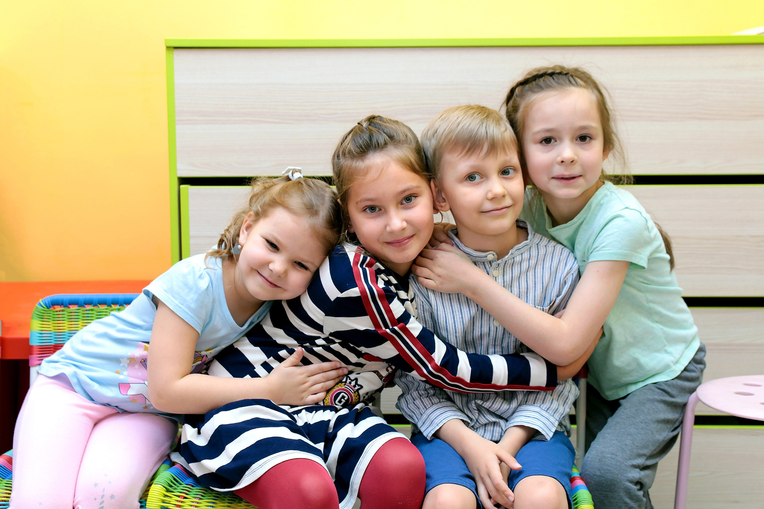 Три девочки обнявшись сидят, а рядом с ними всего лишь один мальчик