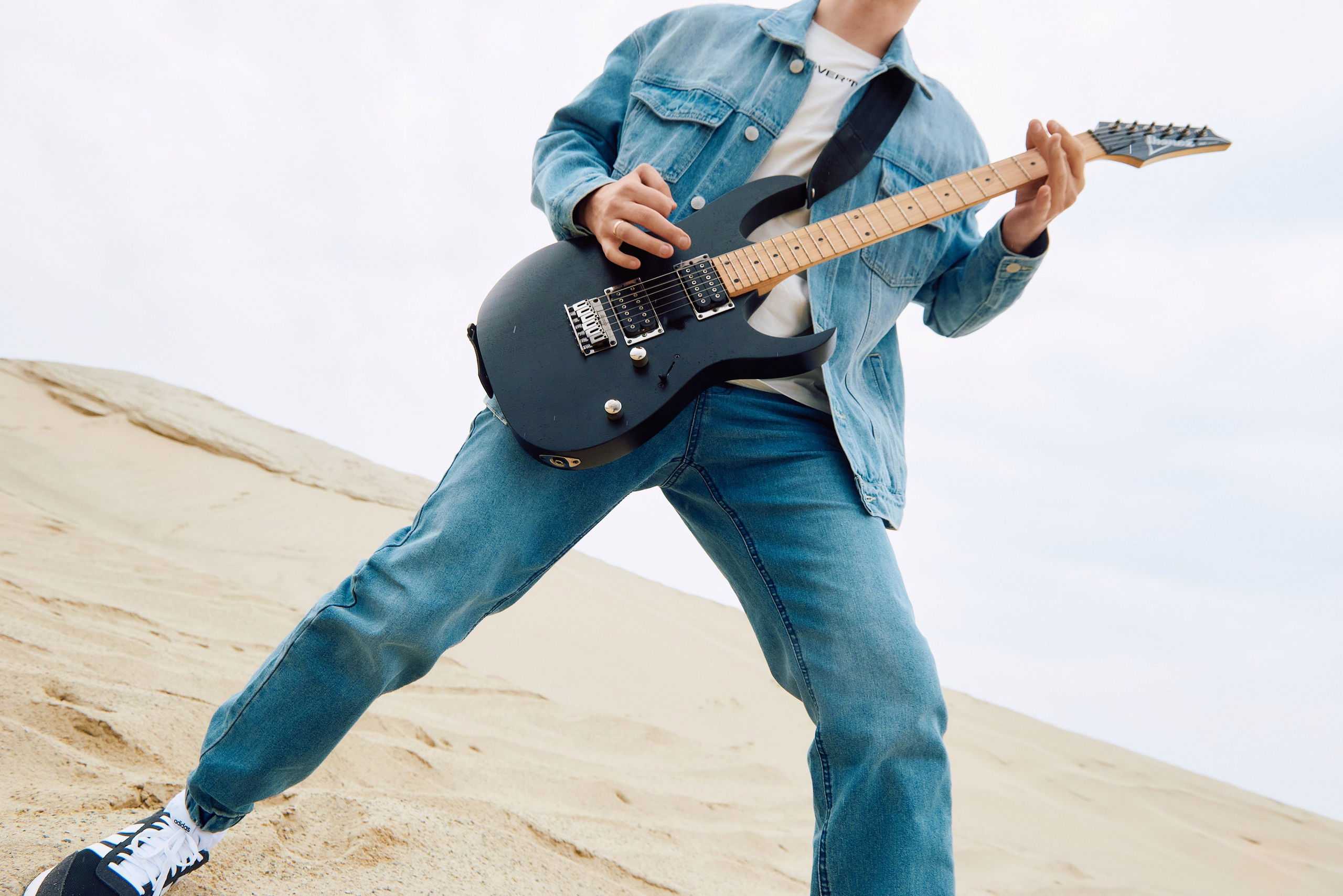 Парень играет на гитаре в пустыне