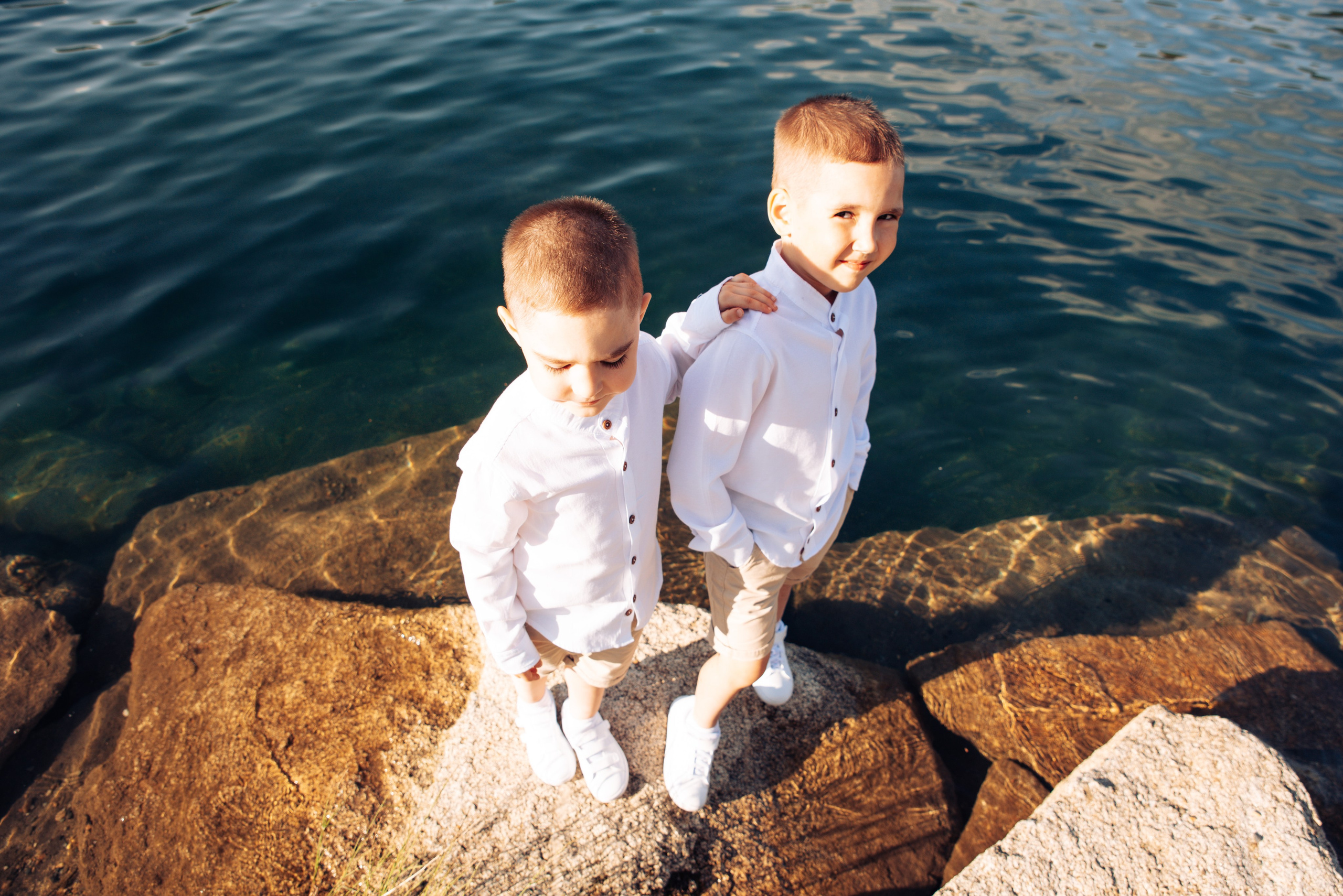 Семейная прогулка летом на берегу озера по пляжу