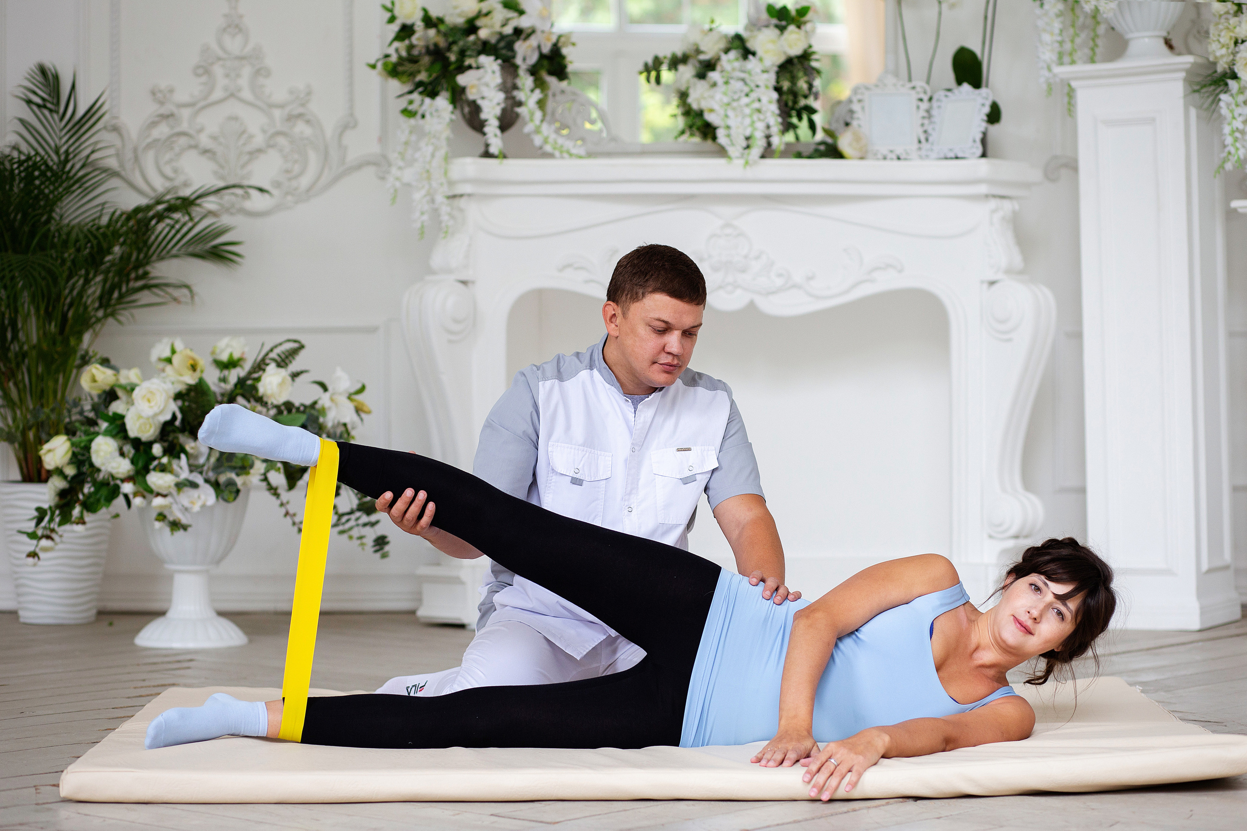 девушка  делает  спортивное  упражнение. инструктор контролирует.