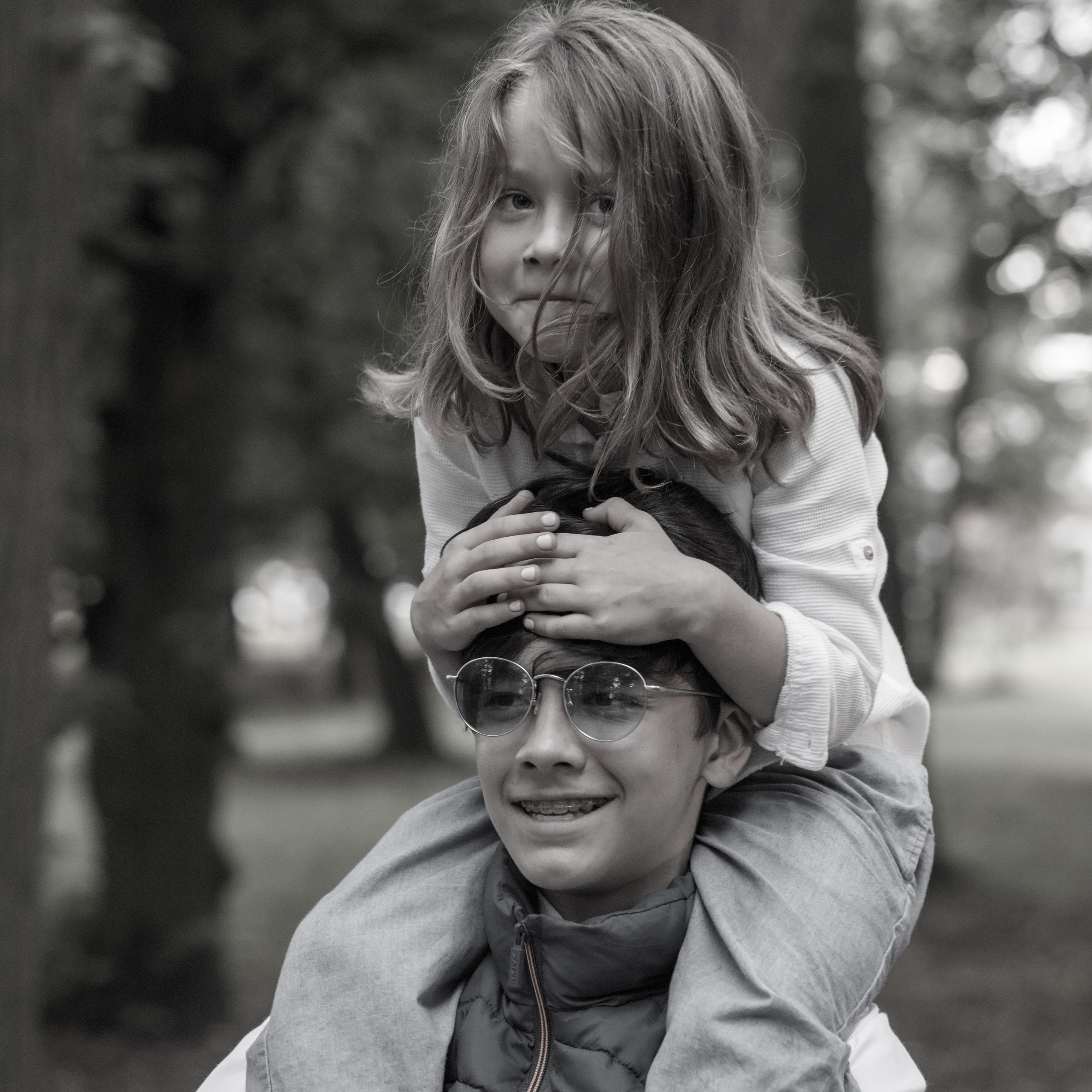 Двое детей в парке, девочка на плечах у брата, чёрно-белый, Москва, Илья Антропов