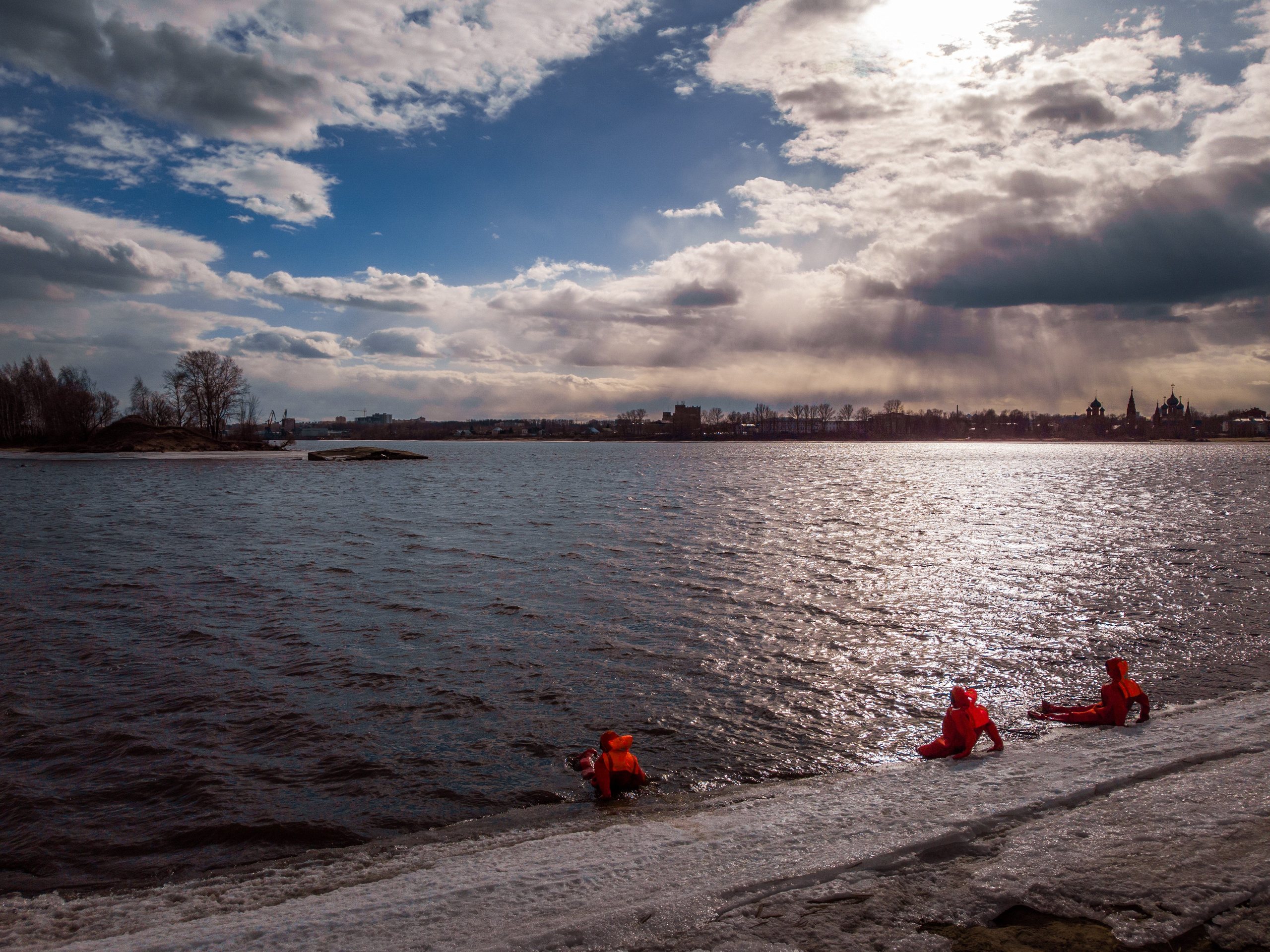 Люди купаются среди льдин, в спасательных оранжевых термо костюмах, айс флоатинг Ярославль