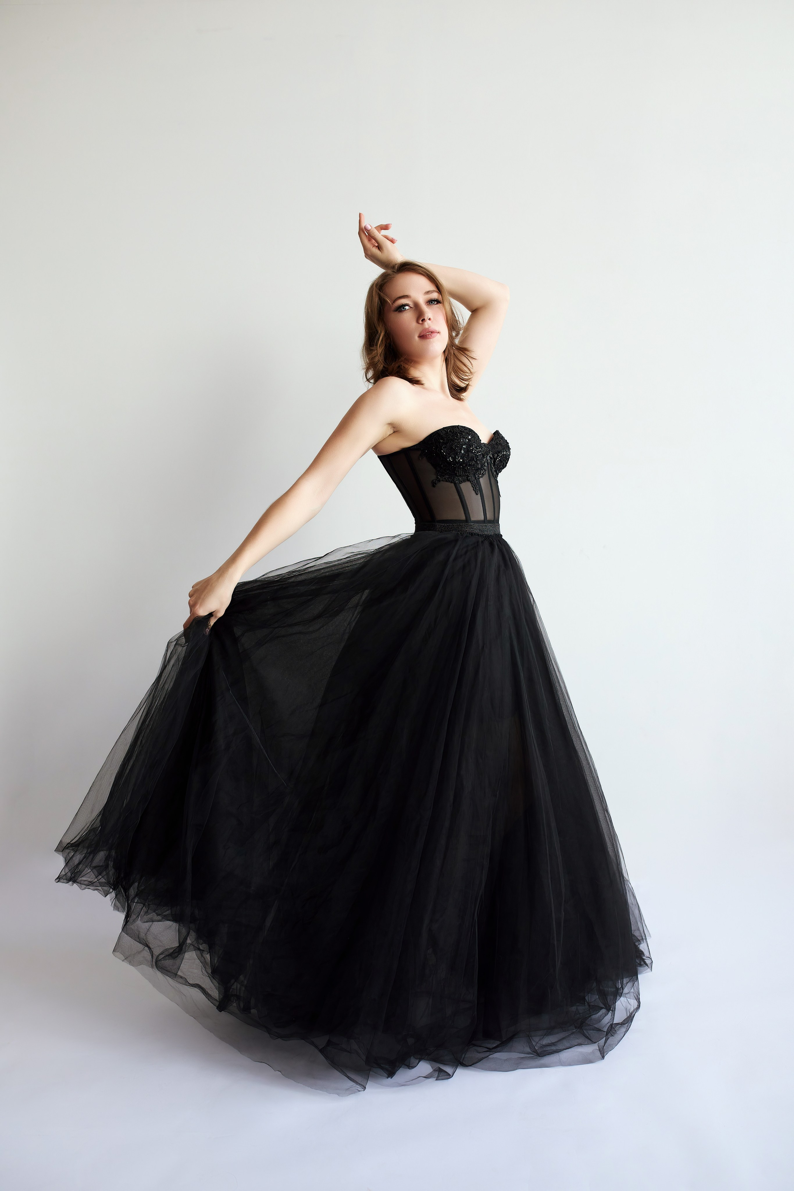 Фотосессия с красивой девушкой, танцующей в длинном платье и держащей одну руку над головой