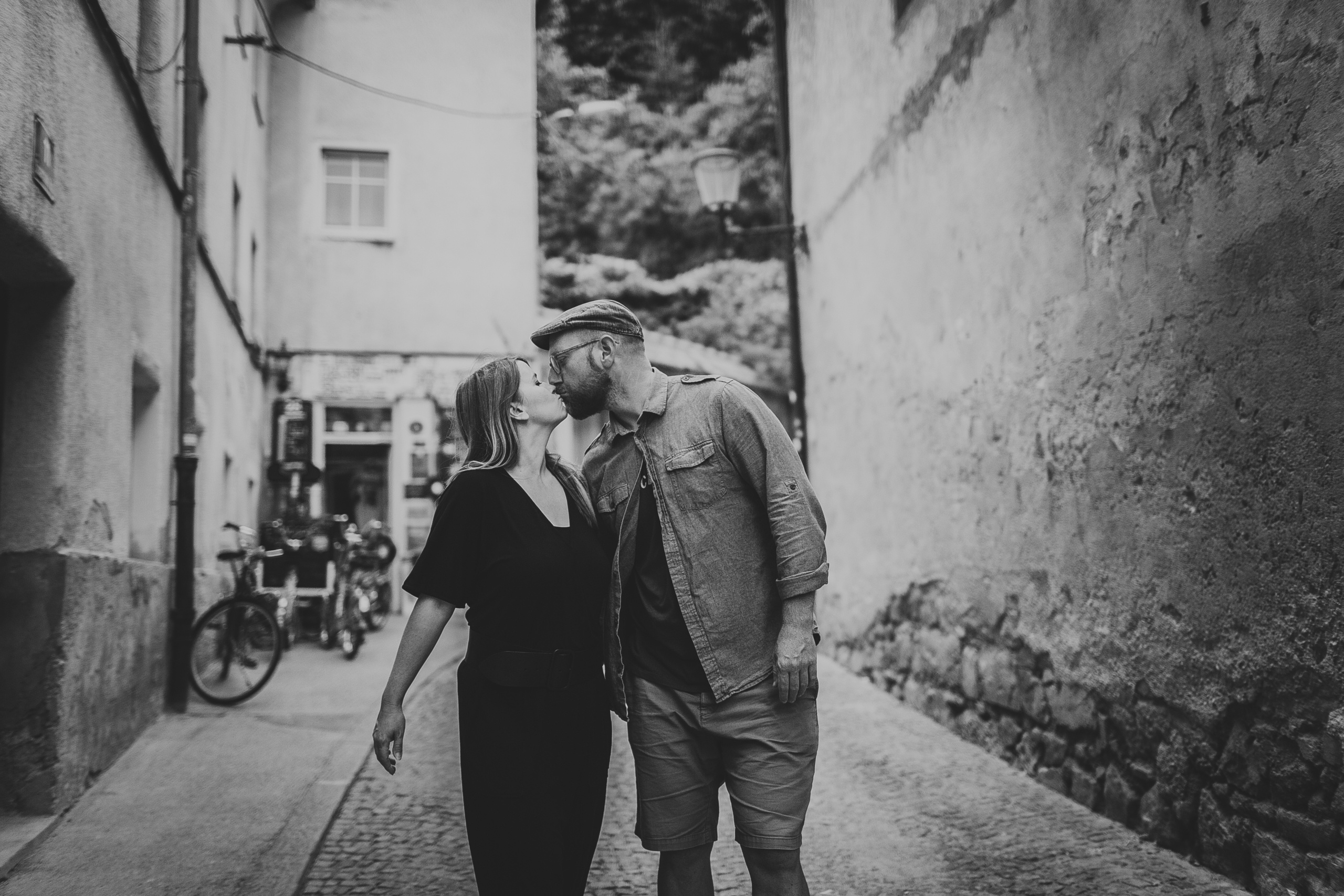 поцелуй влюбленных на маленькой улочке с каменной мостовой