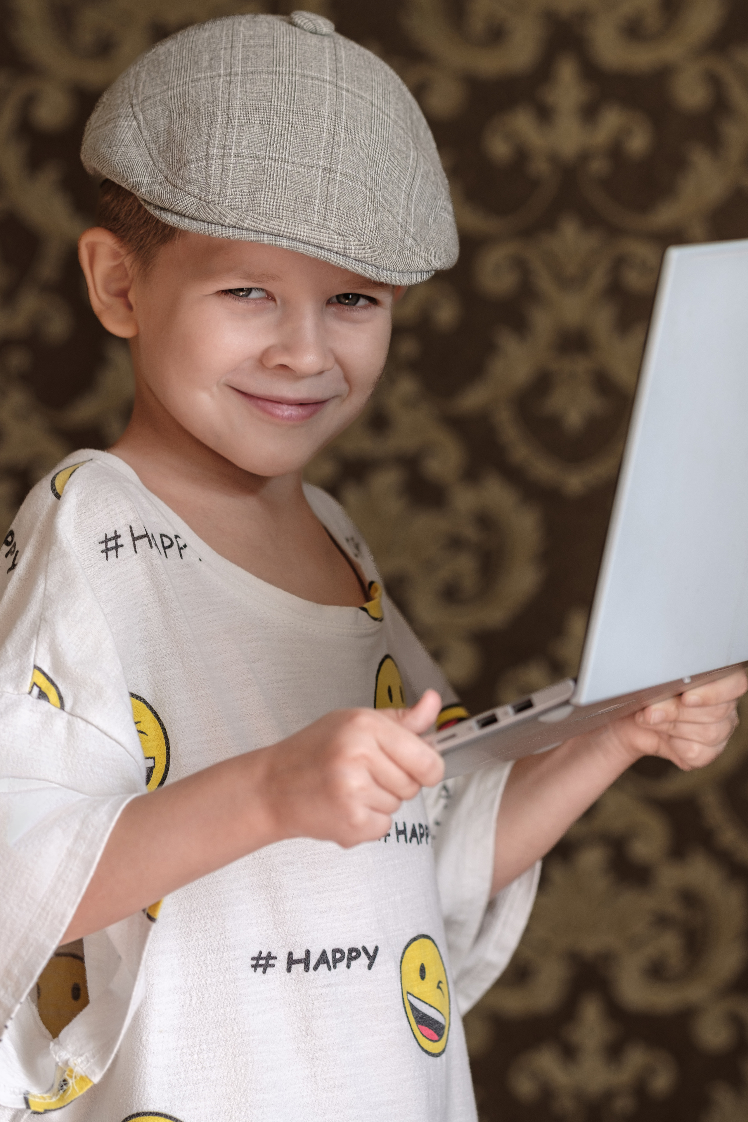 Детский портрет, мальчик показывает кубик Рубика, он в кепке